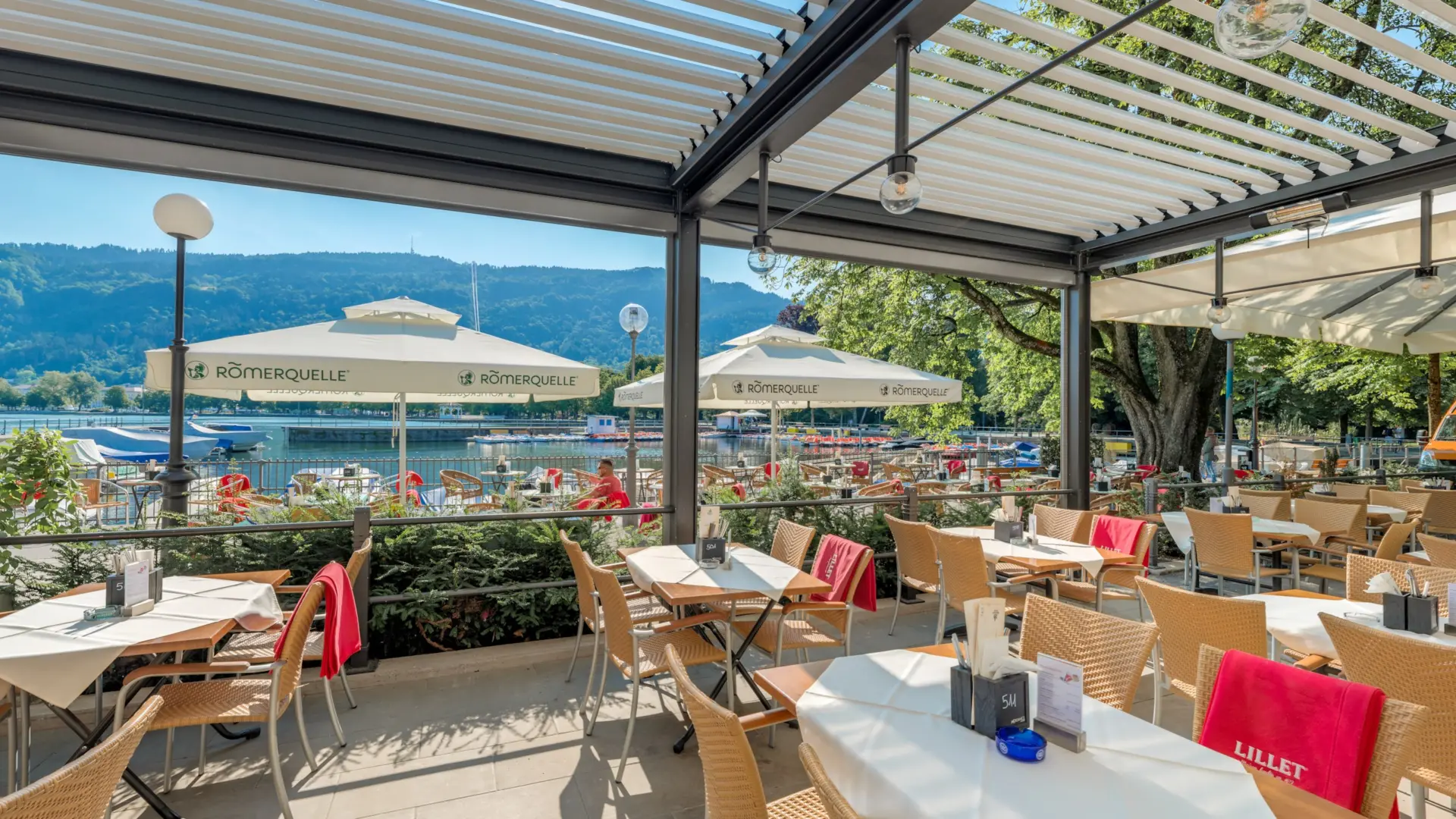 Restaurantterrasse mit Seeblick und Sonnenschirmen
