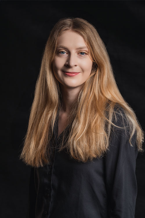 Frau mit langen Haaren in schwarzer Kleidung.