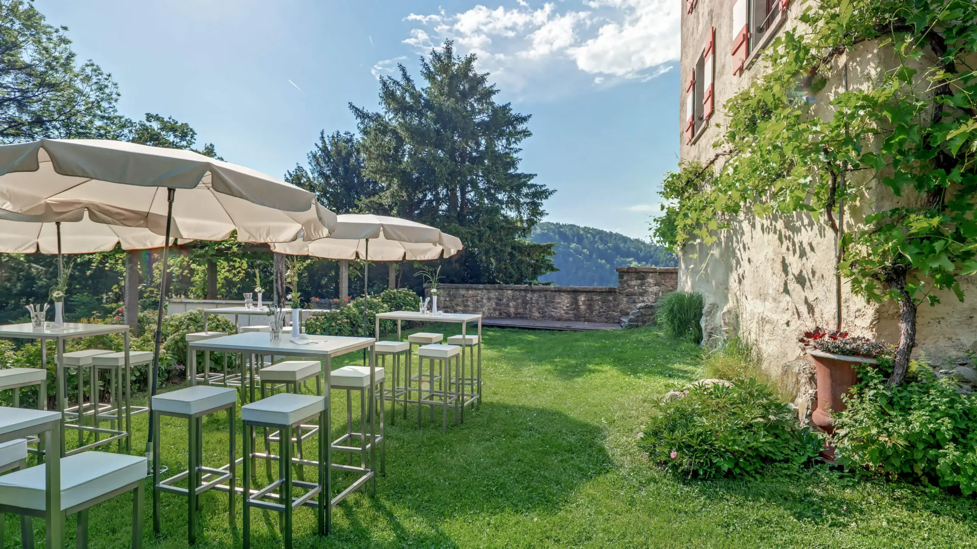 Garten mit Tischen und Sonnenschirmen in der Natur