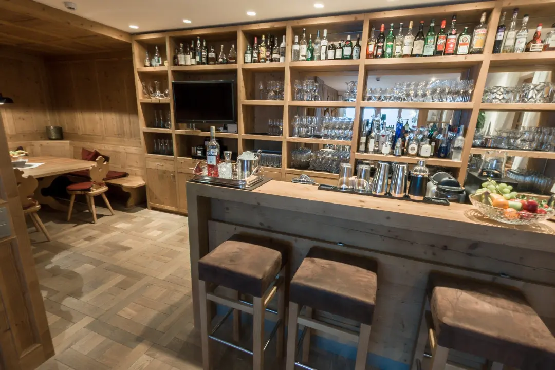 Gemütliche Bar mit Holzdekor und Flaschenregal.