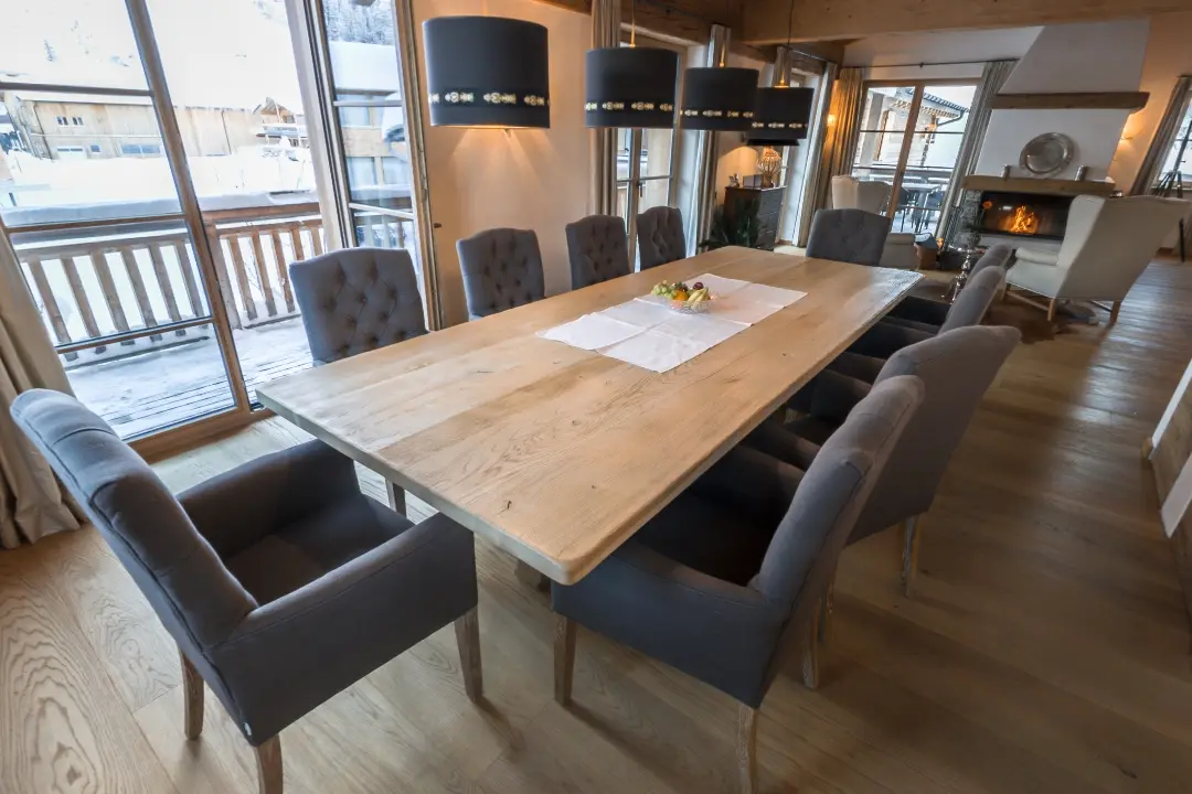 Elegantes Esszimmer mit großem Holztisch und Stühlen.