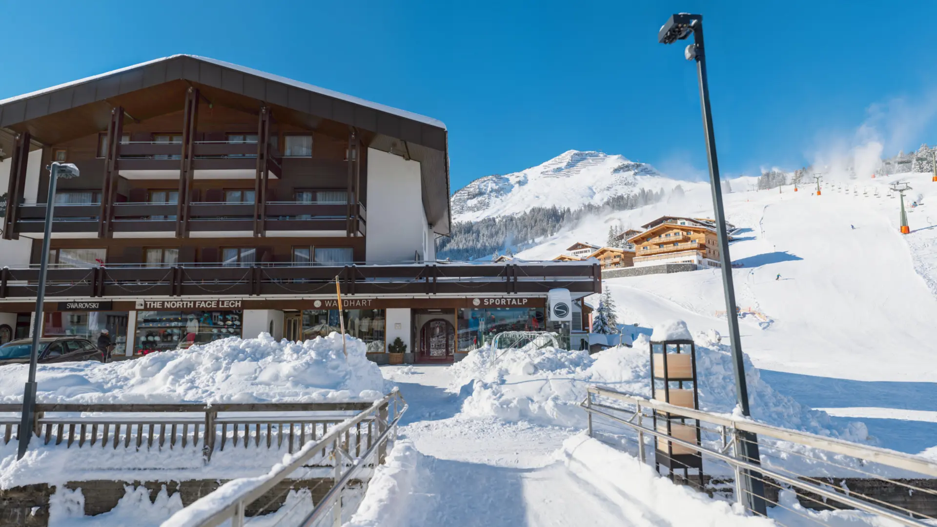 Schneebedecktes Skigebiet mit Gebäuden und blauem Himmel