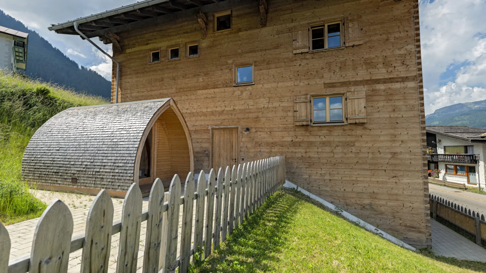 Holzhaus mit Garten und Zaun im Gebirge