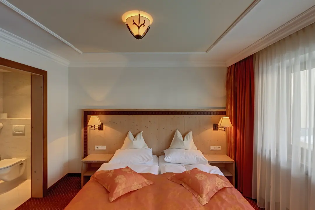 Gemütliches Hotelzimmer mit Doppelbett und Lampen