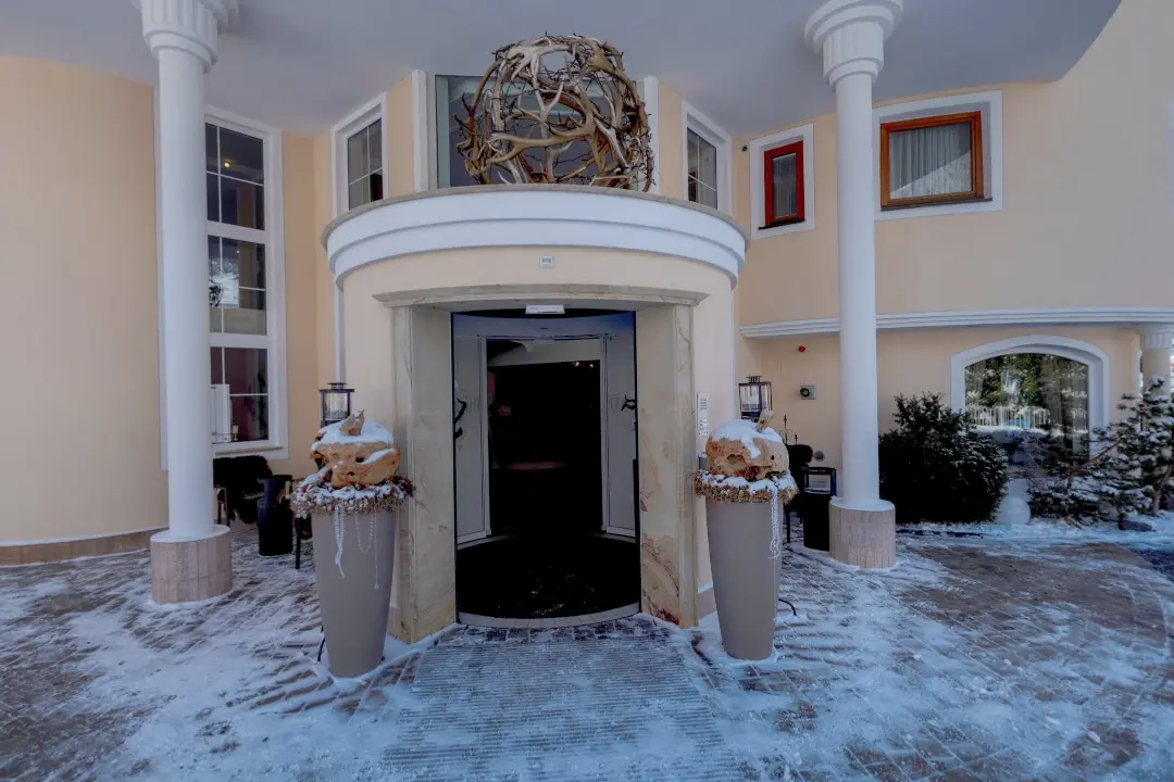 Eingang eines schneebedeckten Gebäudes mit Dekorationen.