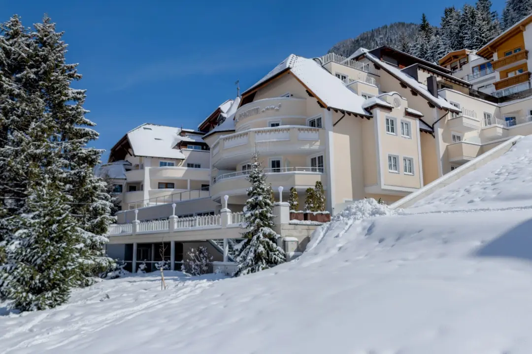 Verschneites Hotelgebäude in malerischer Winterlandschaft.