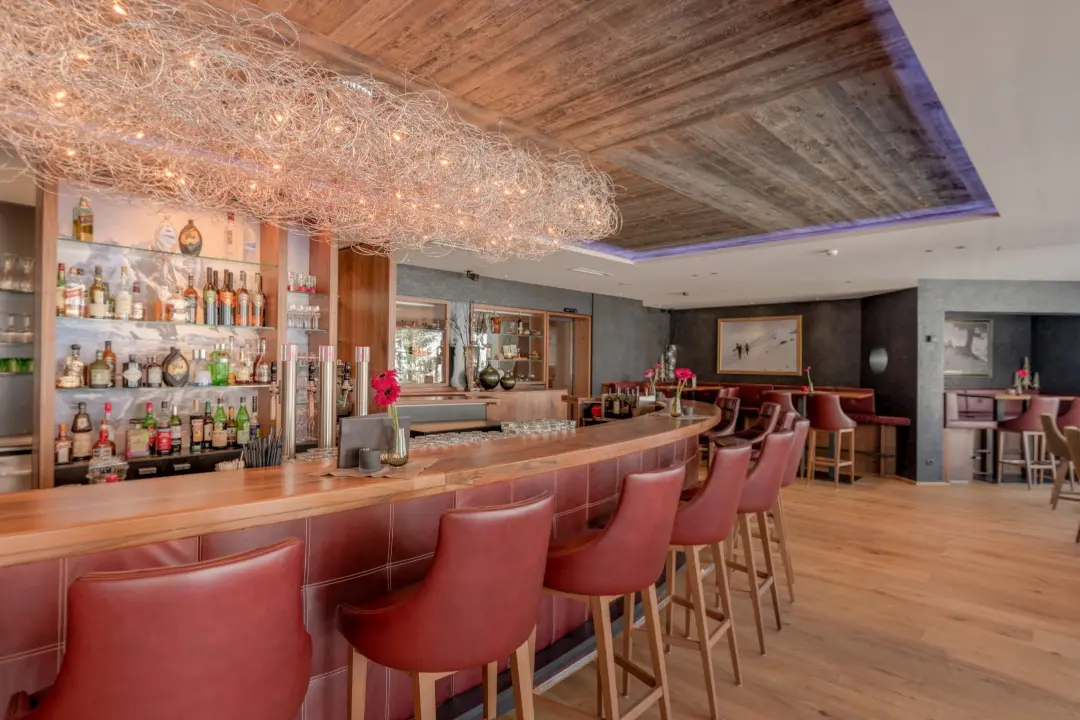 Moderne Bar mit Holztheke und rotbraunen Stühlen