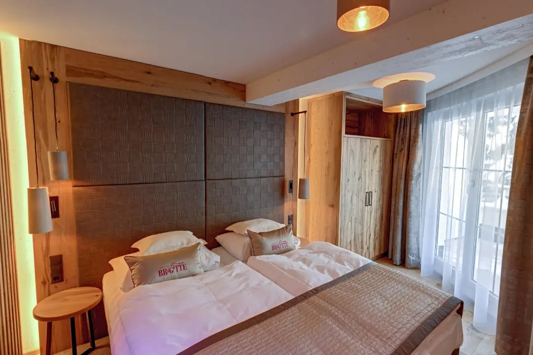 Gemütliches Hotelzimmer mit Doppelbett und Holzelementen.