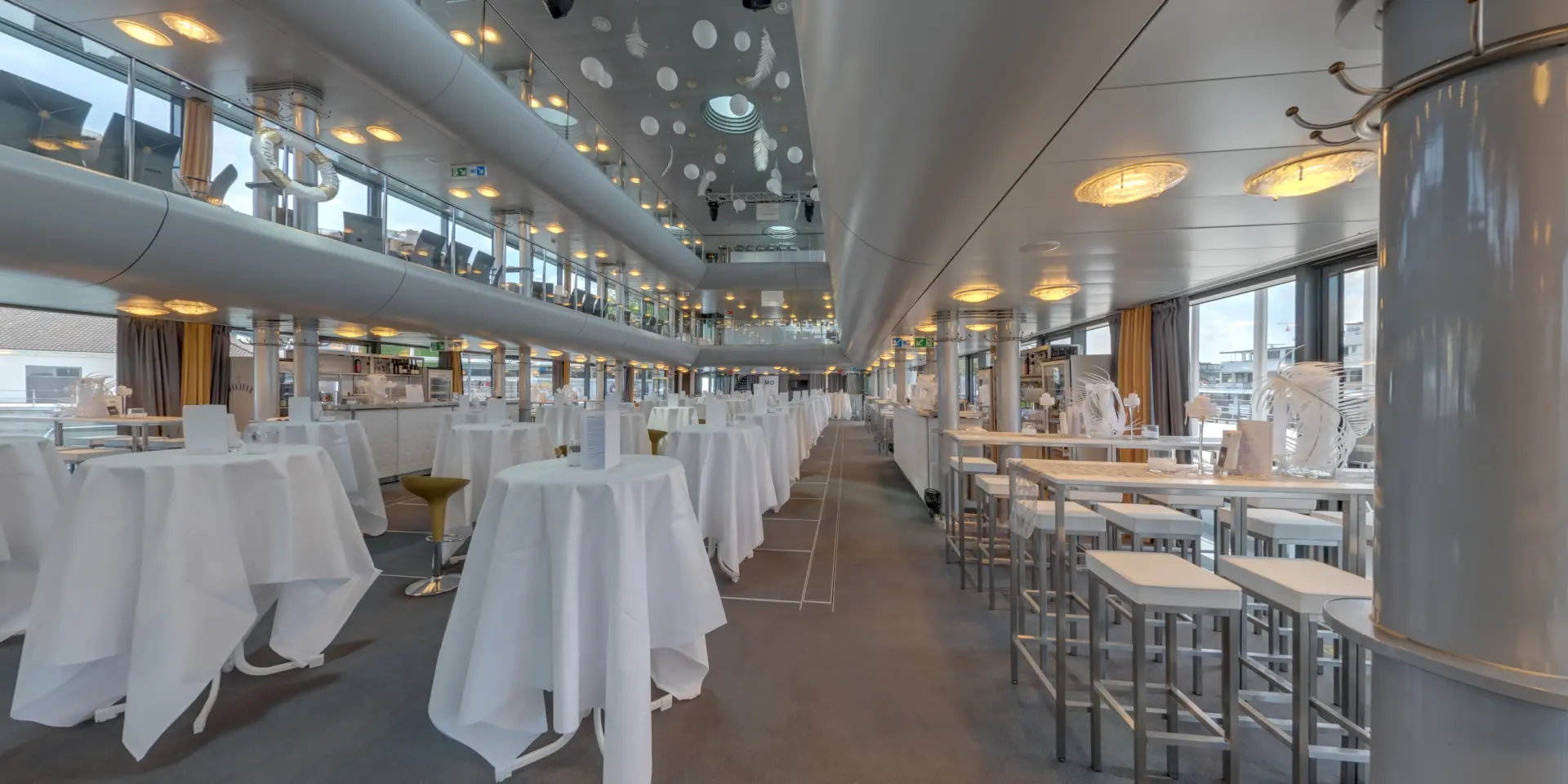 Modernes Restaurantinterieur mit hohen Tischen und Stühlen.