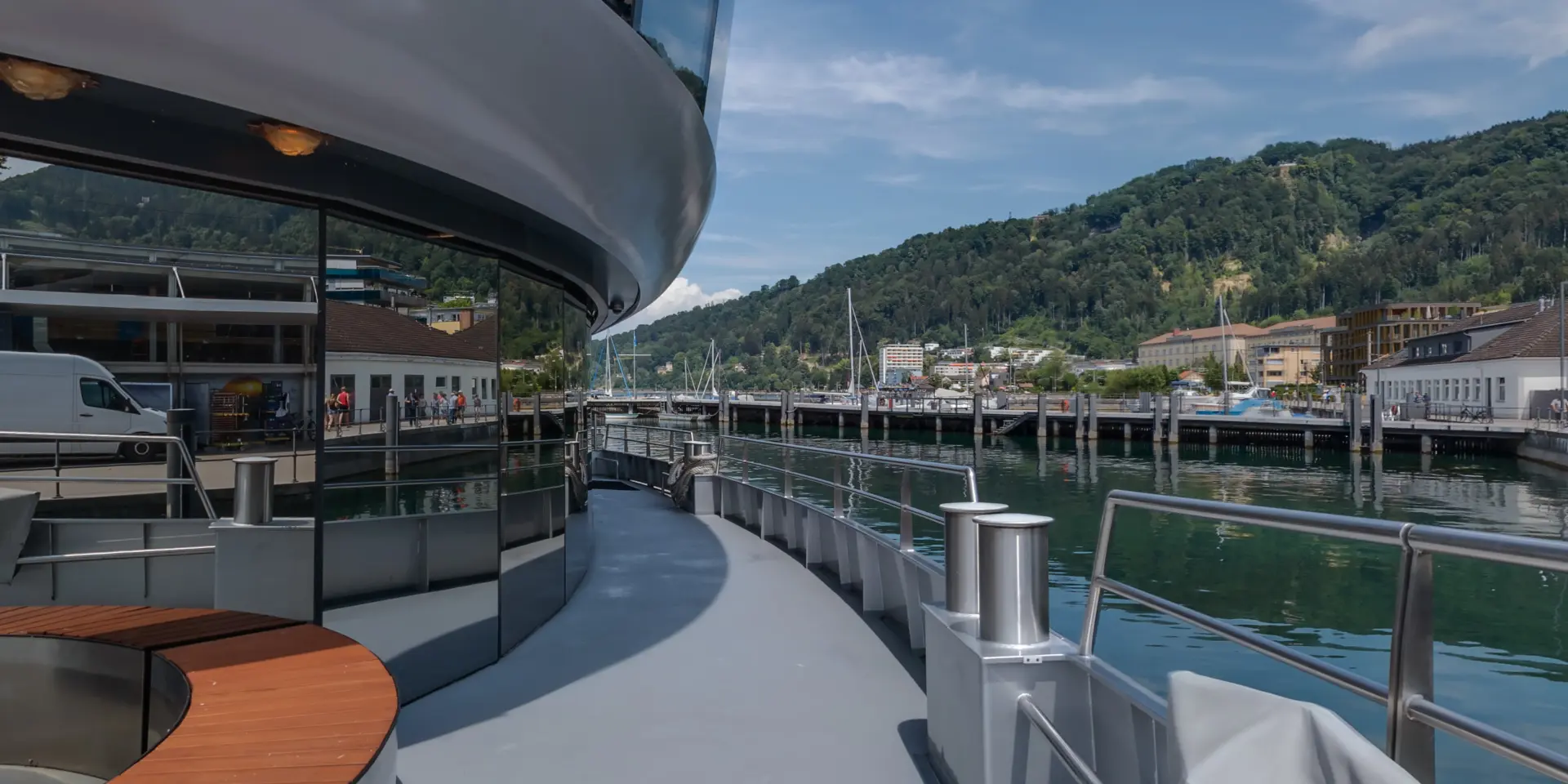 Schiffsdeck mit Blick auf Hafen und Berge.