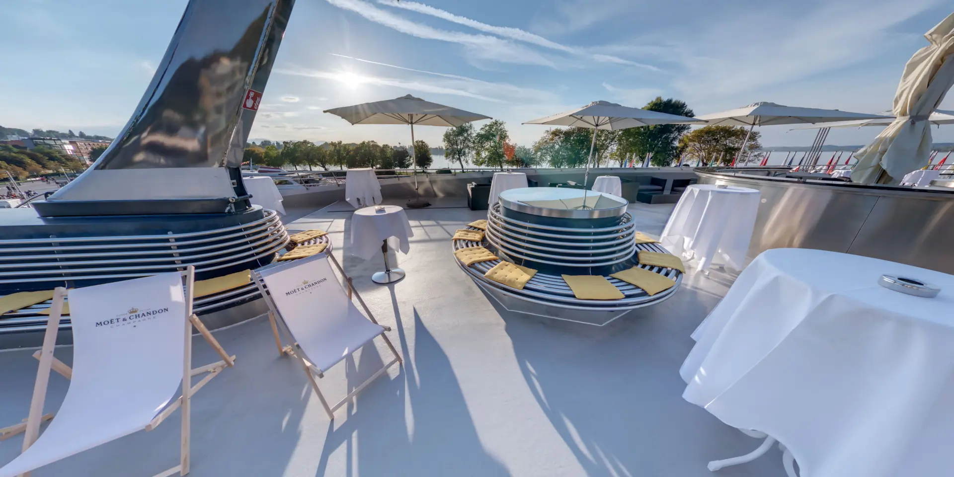 Sonnendeck mit Liegestühlen und Sonnenschirmen auf einem Boot.