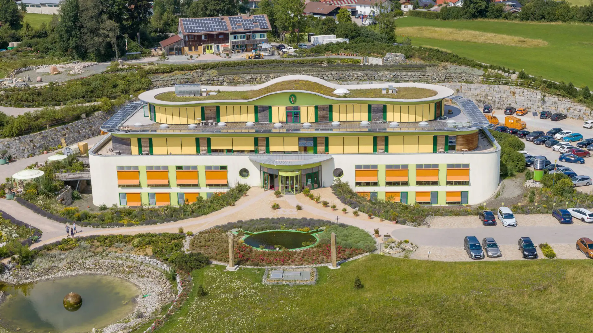 Modernes Gebäude mit grünem Dach und Solarpanels.