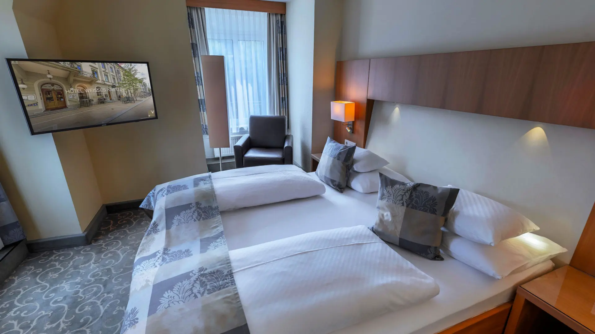 Modernes Hotelzimmer mit Doppelbett und Fernseher