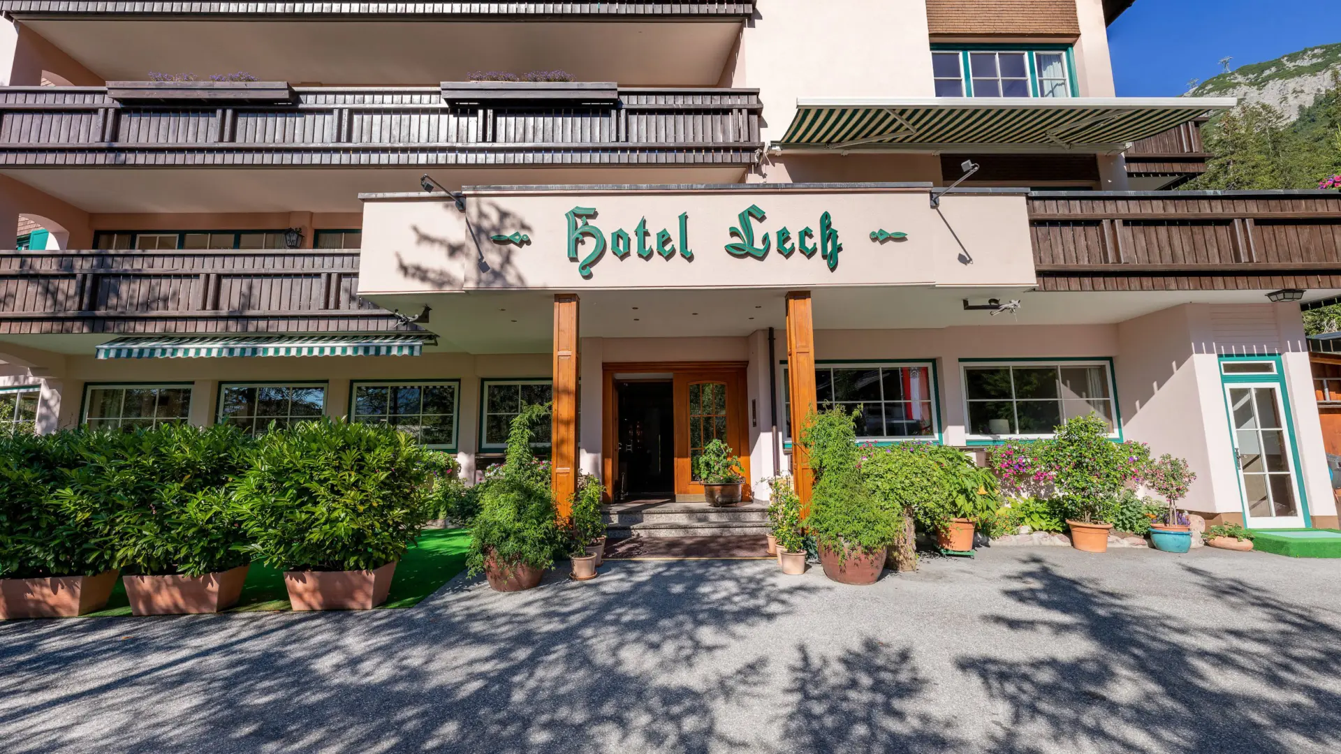 Hotelgebäude mit grüner Beschriftung und Pflanzen