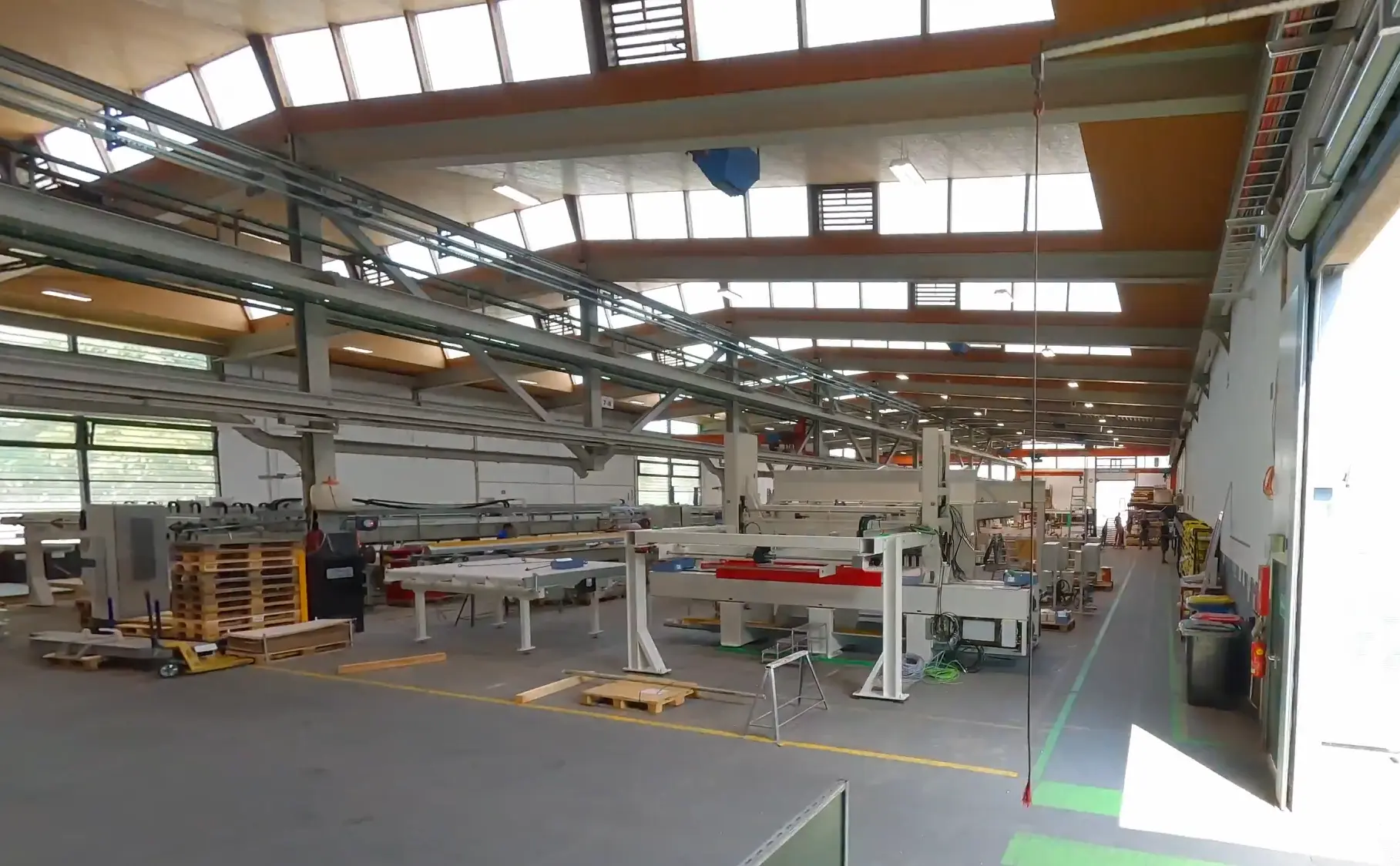 Moderne Fabrikhalle mit Maschinen im Sonnenlicht