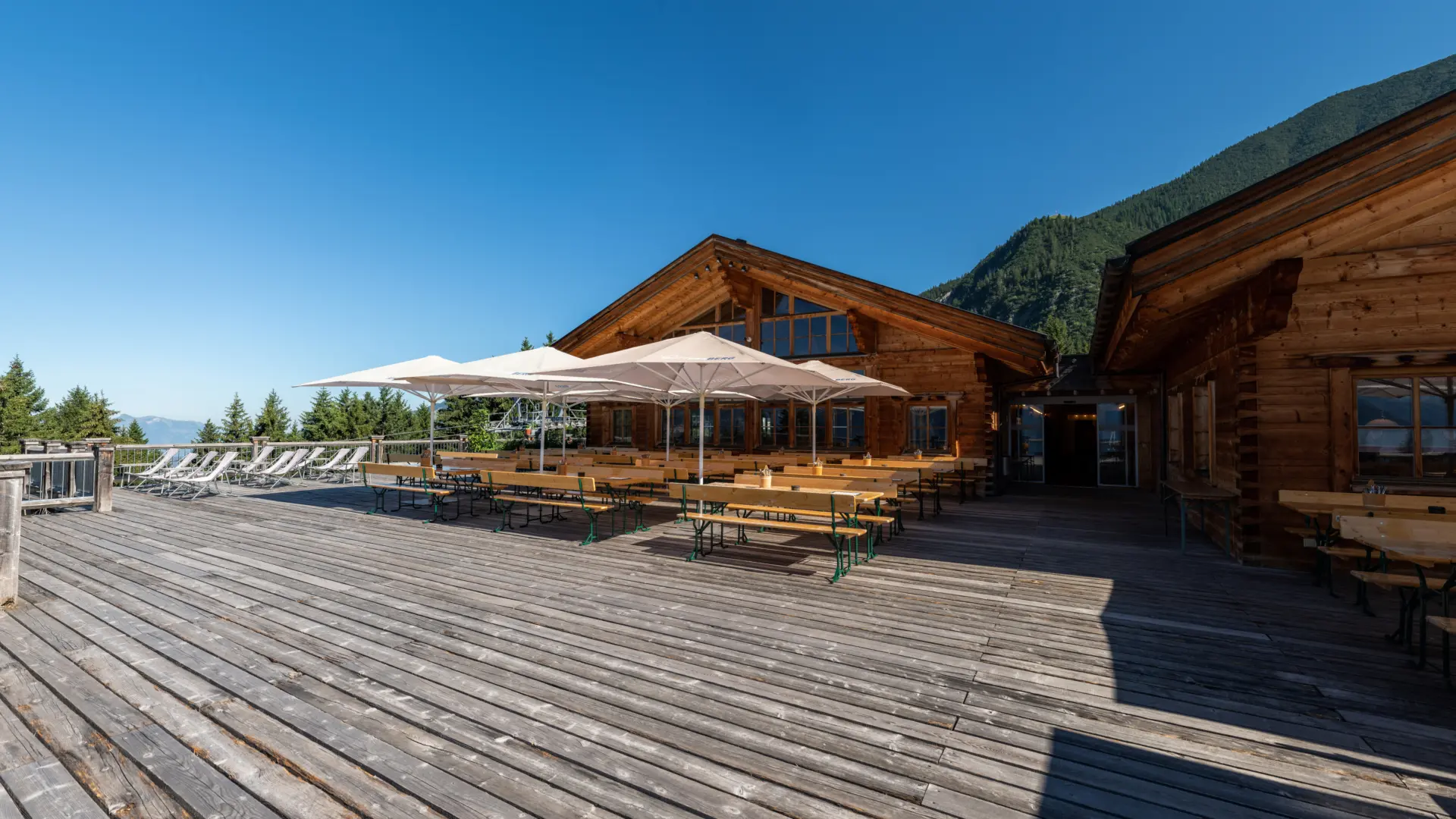 Holzhütte mit Terrasse und Sonnenschirmen