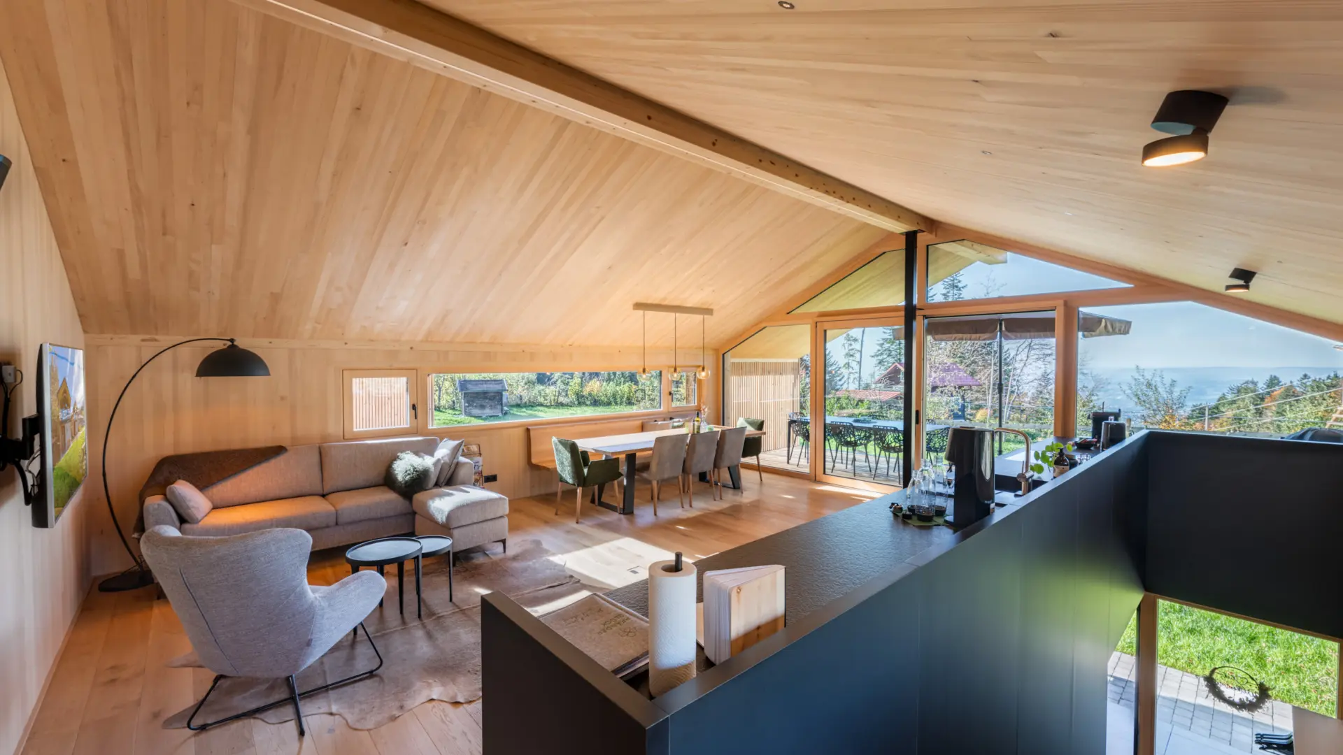 Modernes Wohnzimmer mit Holzdecke und Panoramafenster.