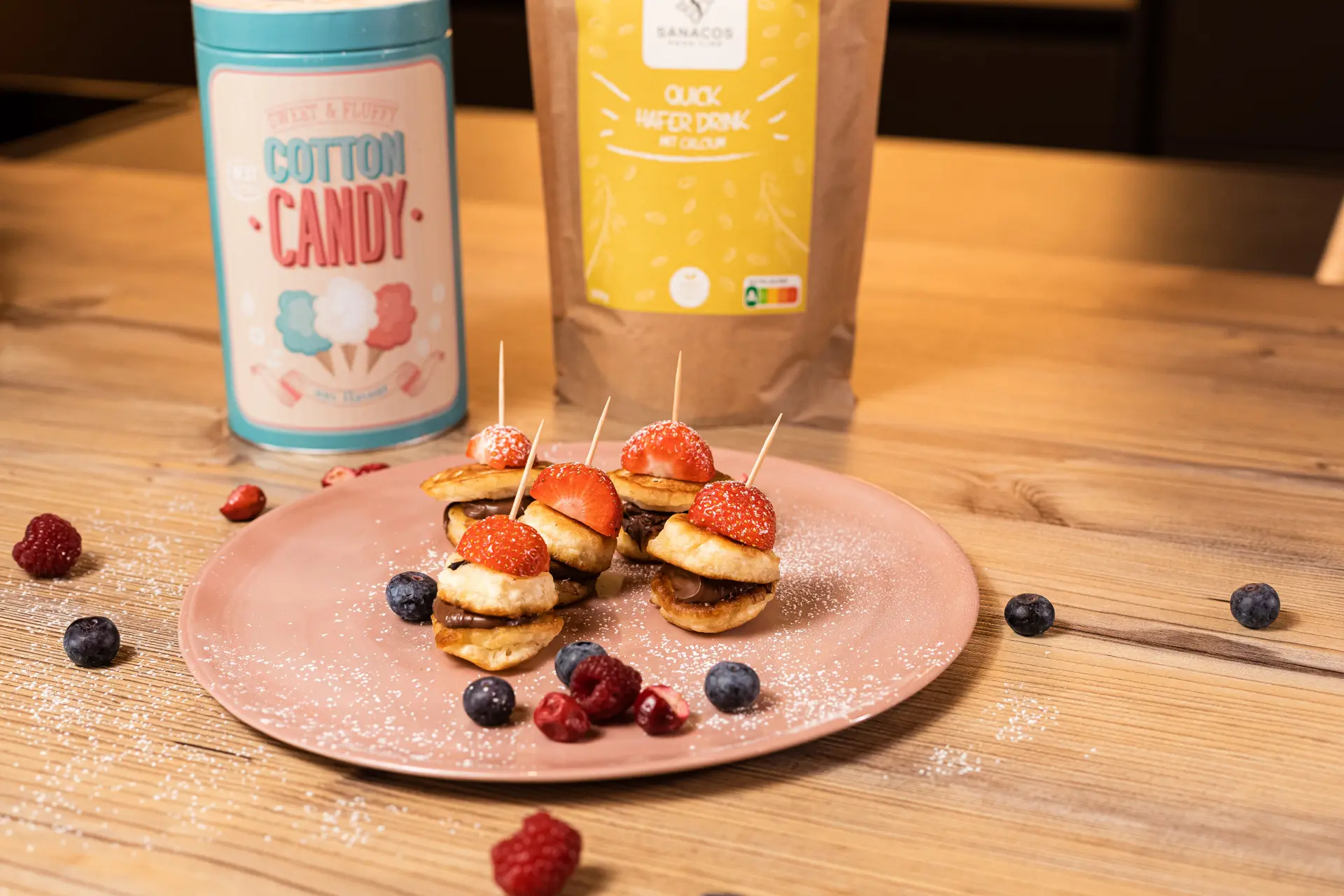 Mini-Pfannkuchen mit Erdbeeren und Schokolade auf Teller.