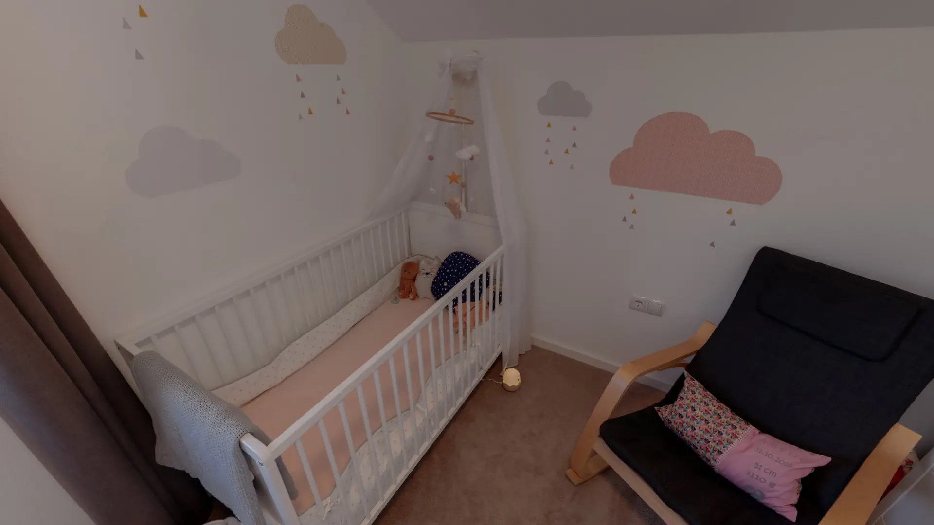 Kinderzimmer mit Gitterbett und Sessel