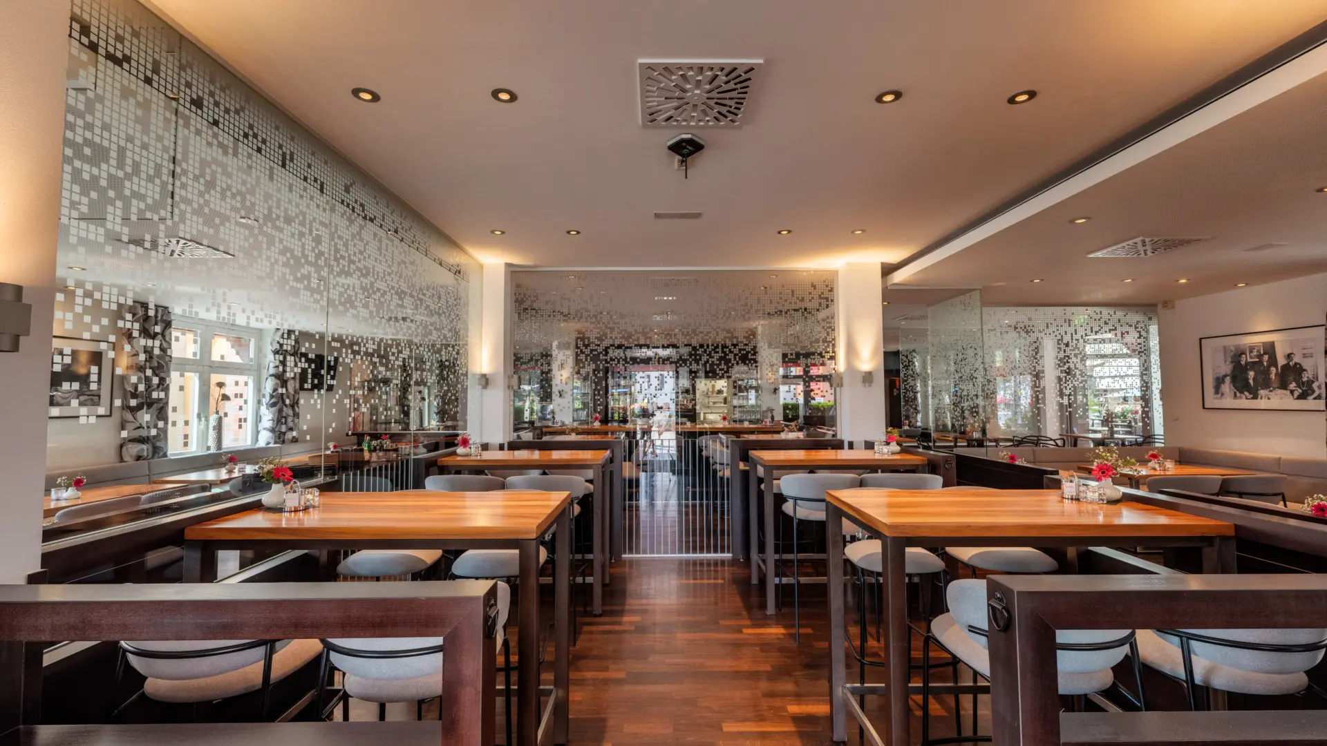 Modernes Restaurant mit Holztischen und dekorativen Wänden.