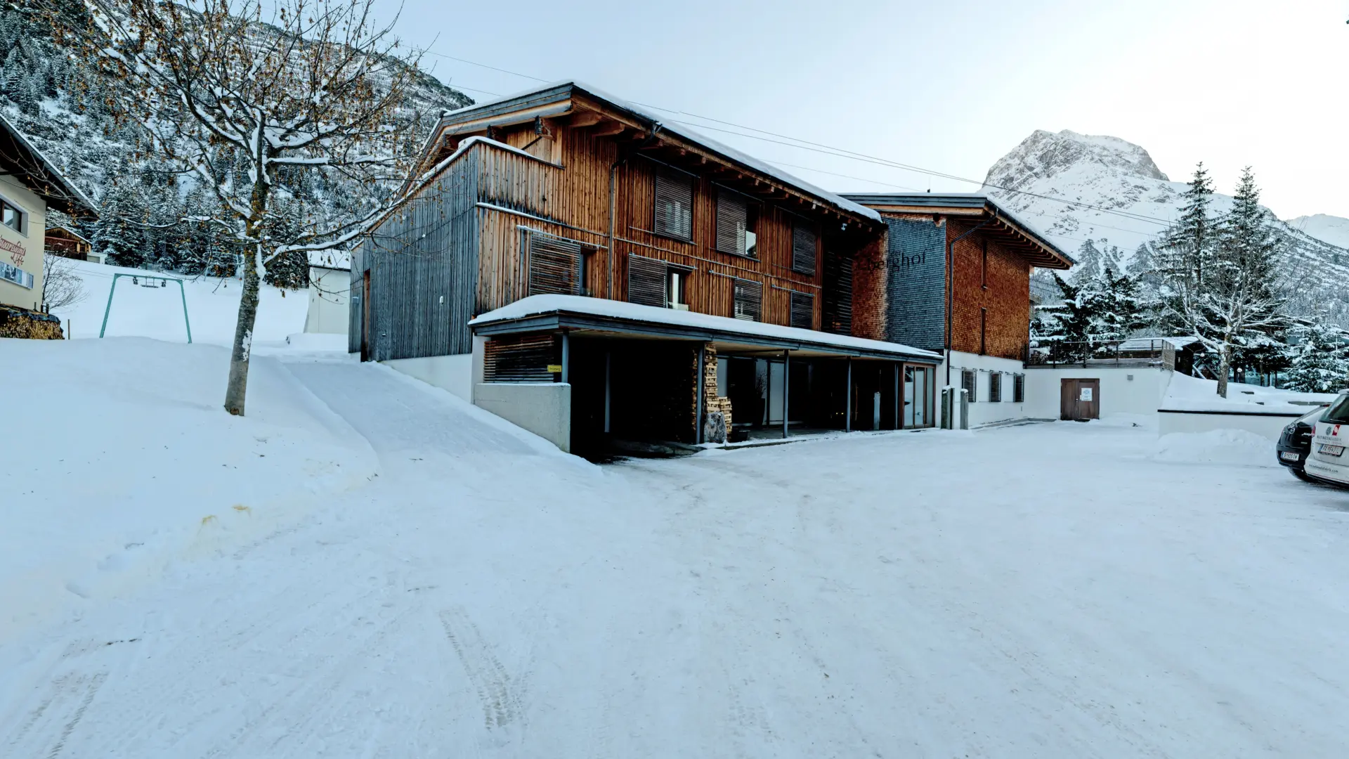Holzhaus im Schnee mit Bergkulisse