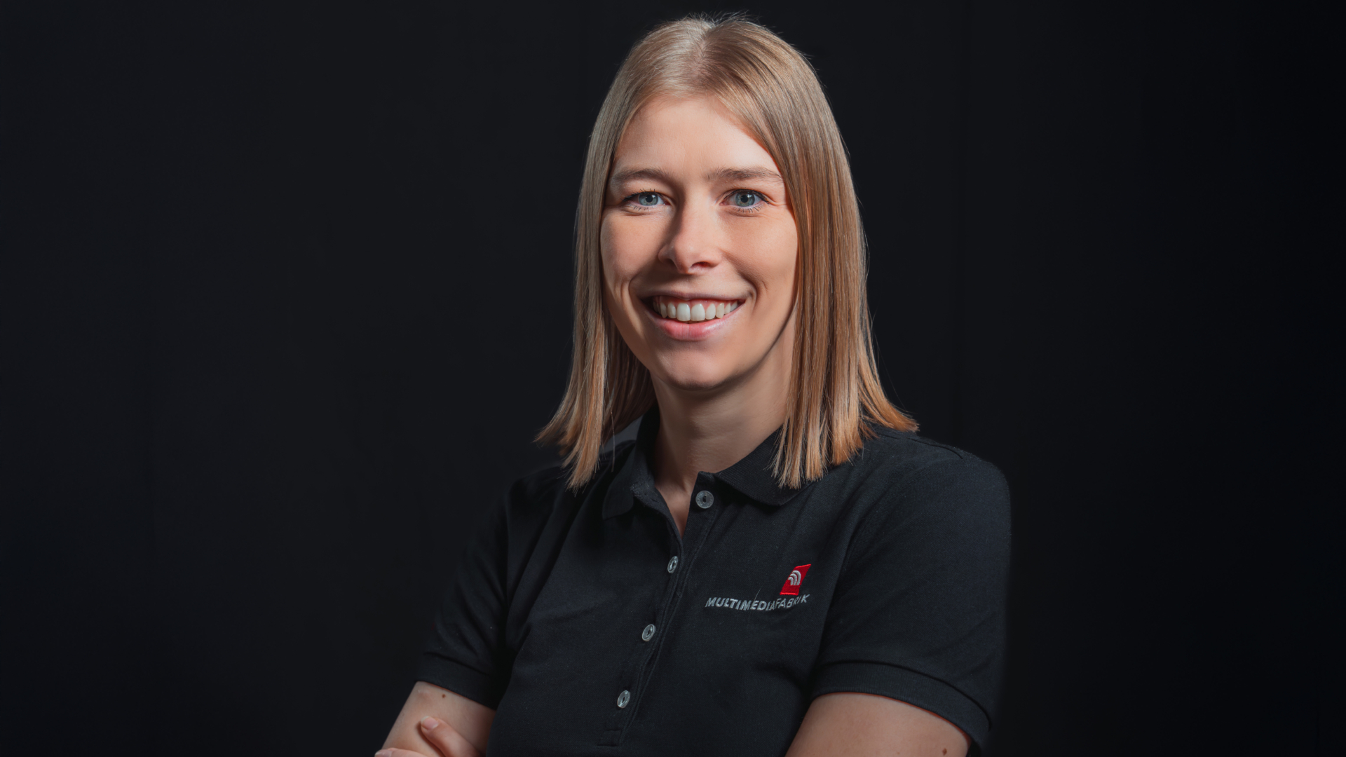 Person lächelt in schwarzem Polohemd