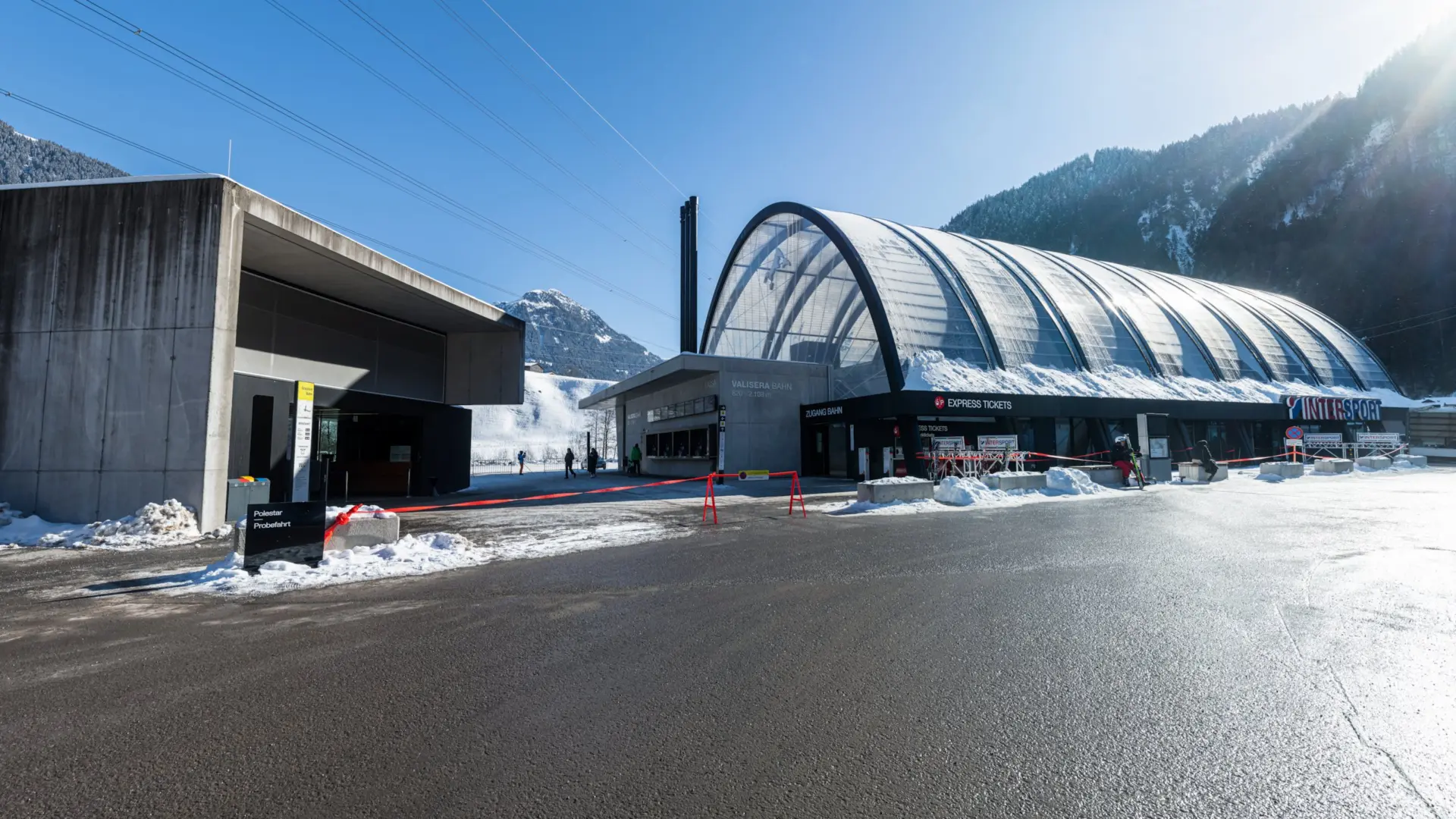 Moderne Seilbahnstation in winterlicher Berglandschaft.