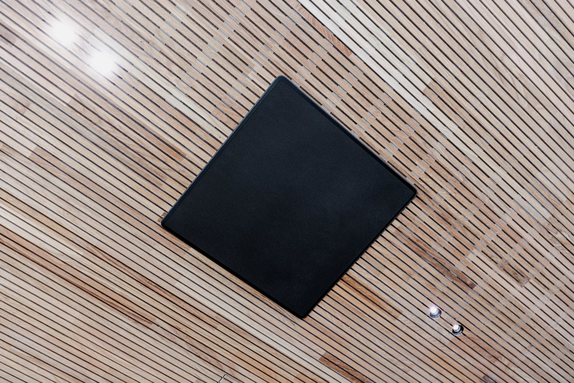 Schwarzes Quadrat auf holzgemusterter Decke