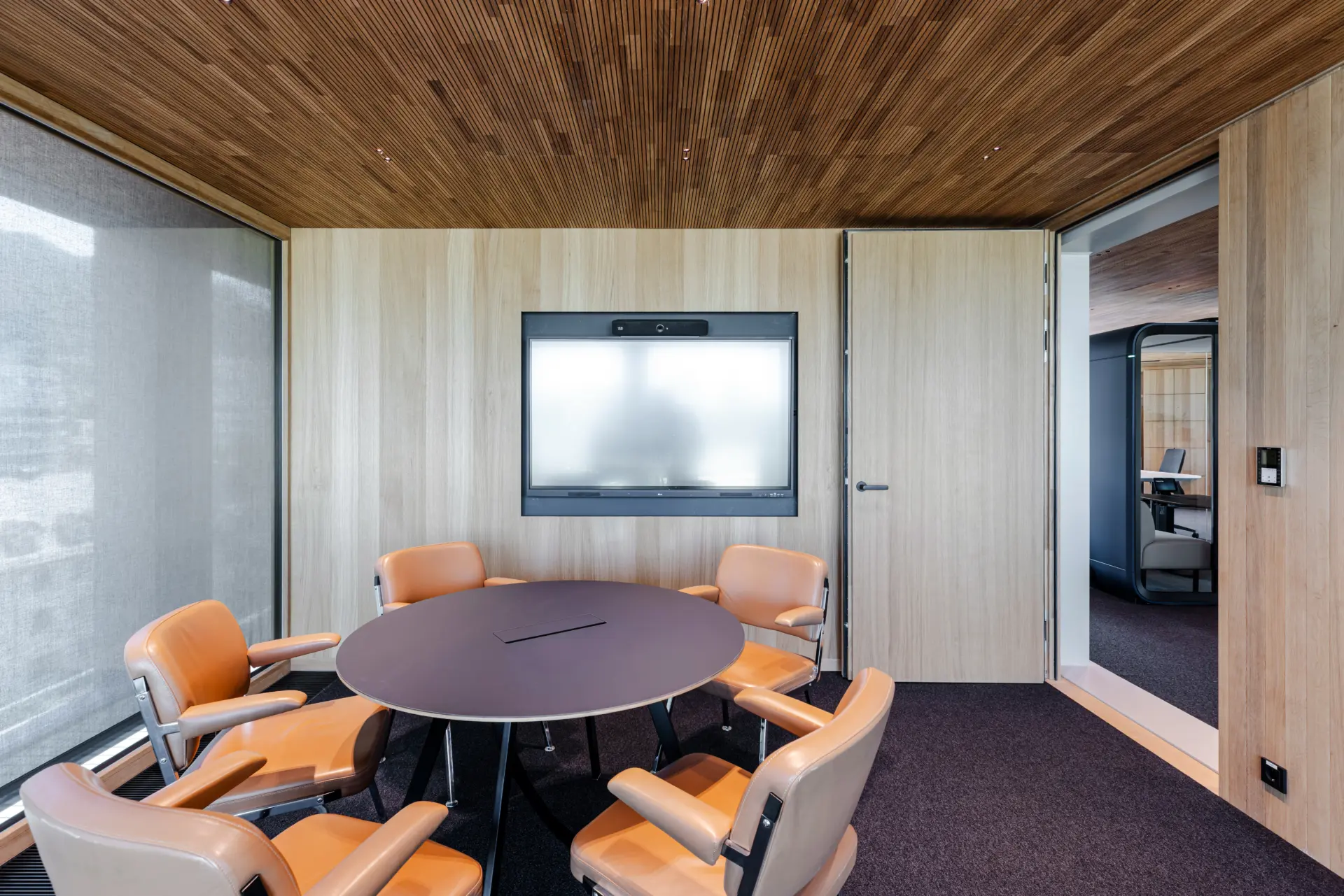 Moderner Konferenzraum mit Tisch und Stühlen.