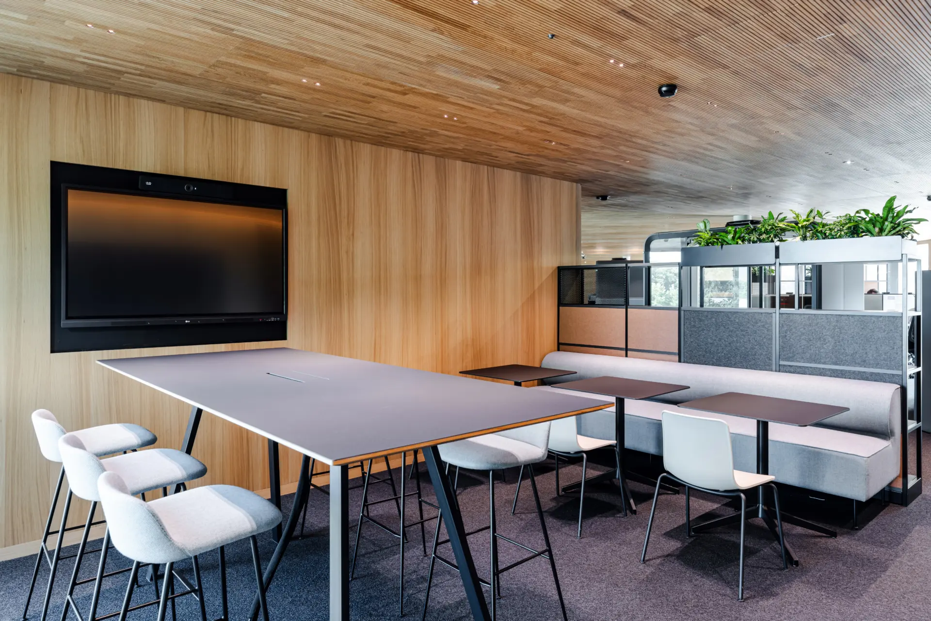 Moderner Konferenzraum mit Holzwänden und Pflanzen.