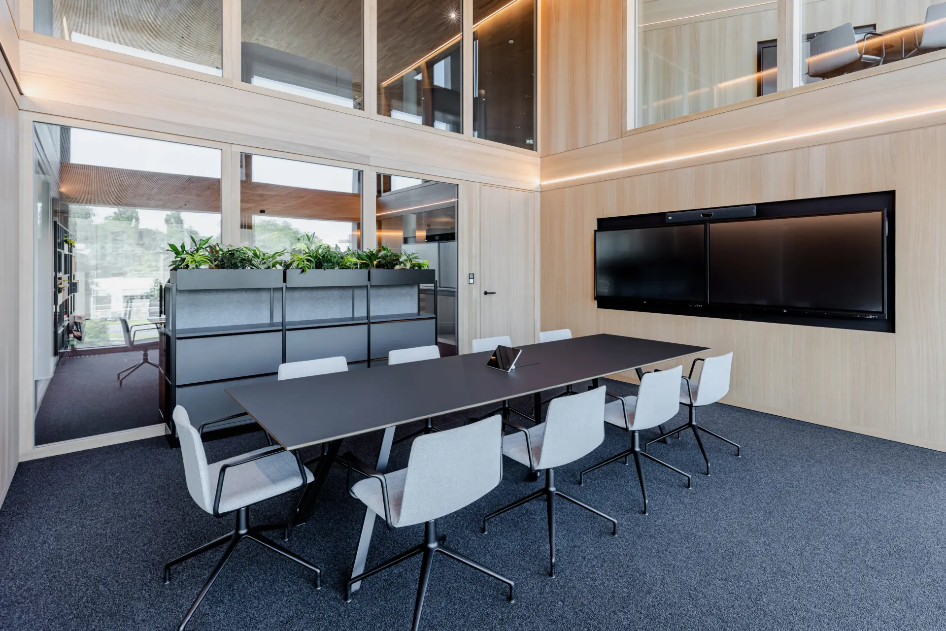 Moderner Konferenzraum mit Tisch und Stühlen.