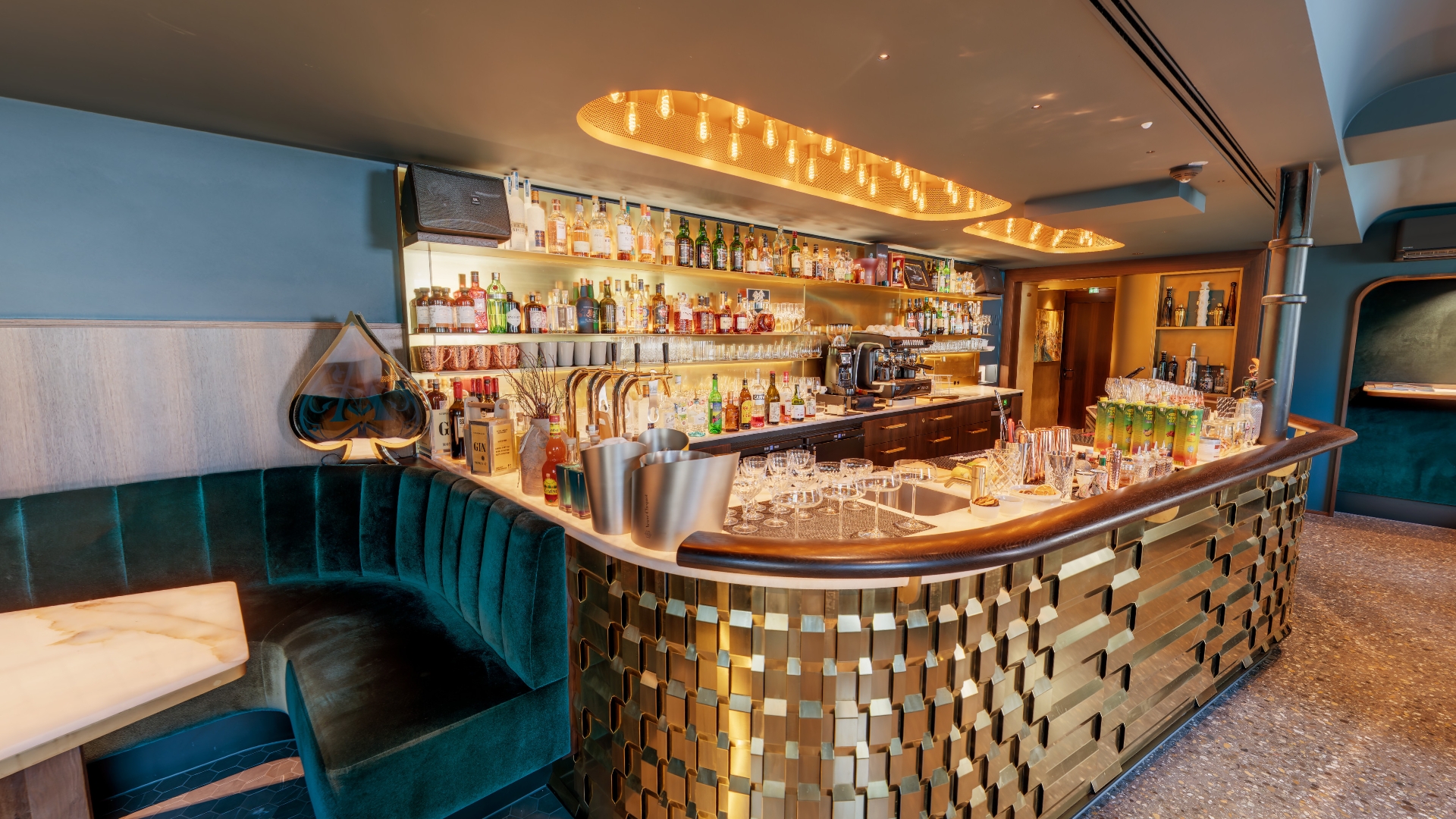 Moderne Bar mit goldener Theke und Spirituosen