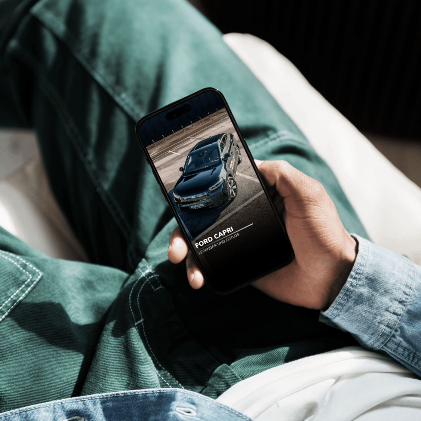 Person hält Smartphone, zeigt Ford Capri Automobilbild.