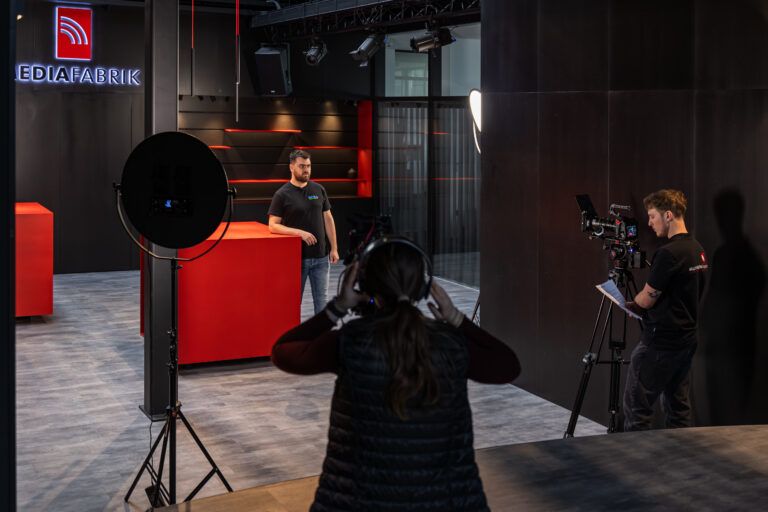 Videodreh im modernen Studio mit rotem Design.