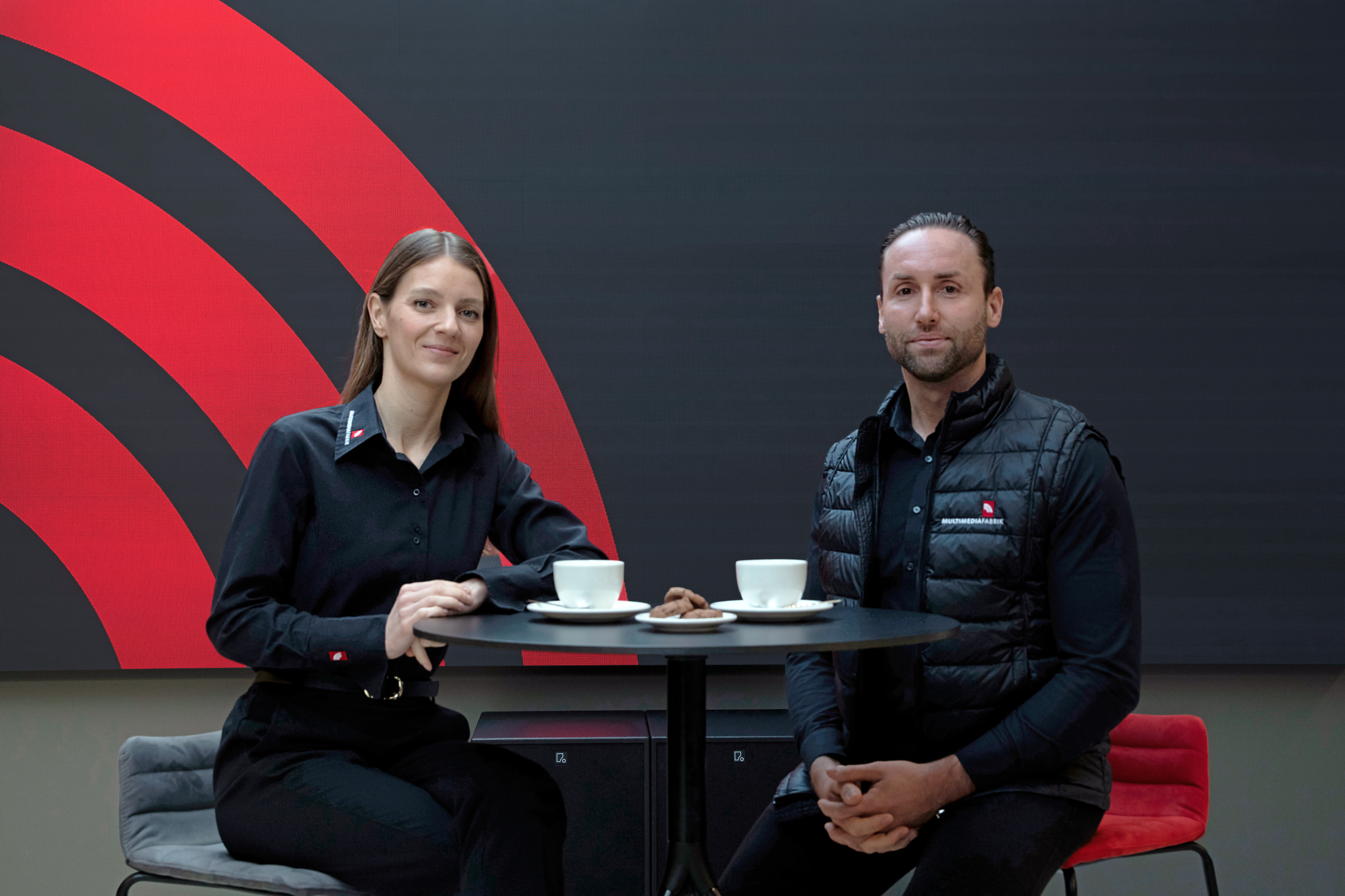 Zwei Menschen trinken Kaffee an einem Tisch.