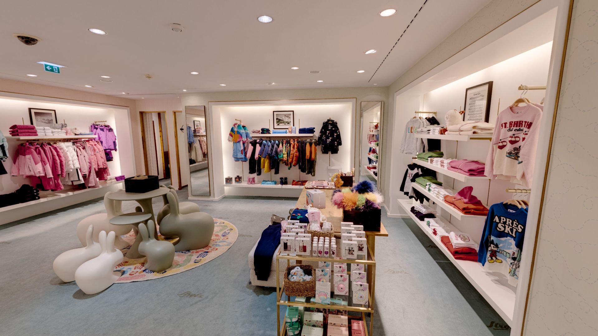 Kinderbekleidungsgeschäft mit bunten Kleidern und Spielzeug.