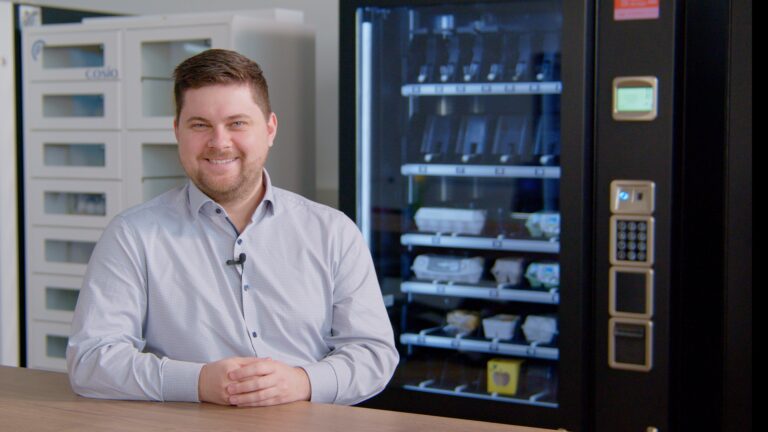 Mann vor Snackautomat im Büro