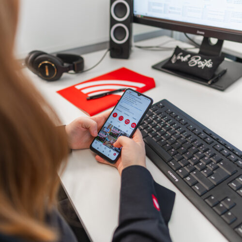 Person benutzt Smartphone am Schreibtisch