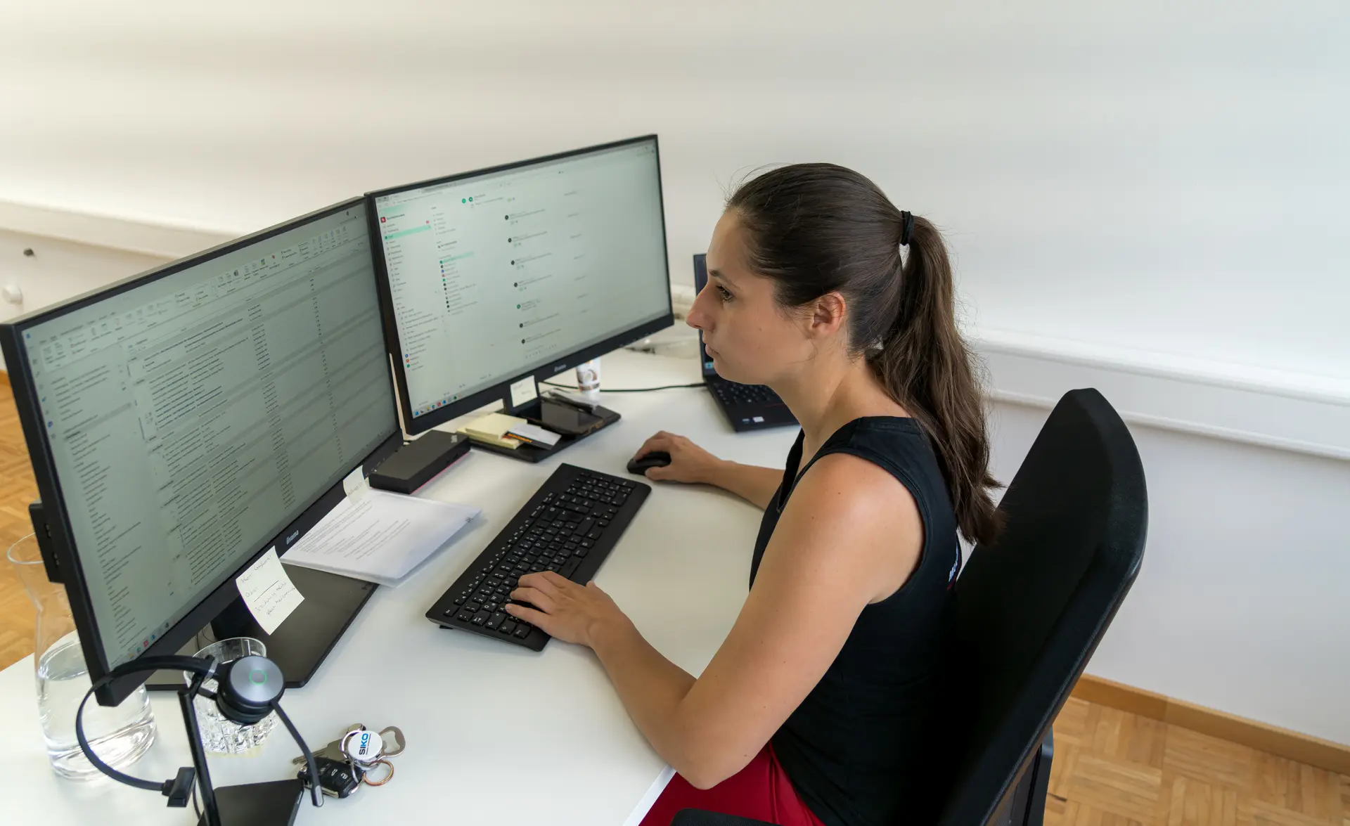 Frau arbeitet am Computer mit zwei Monitoren