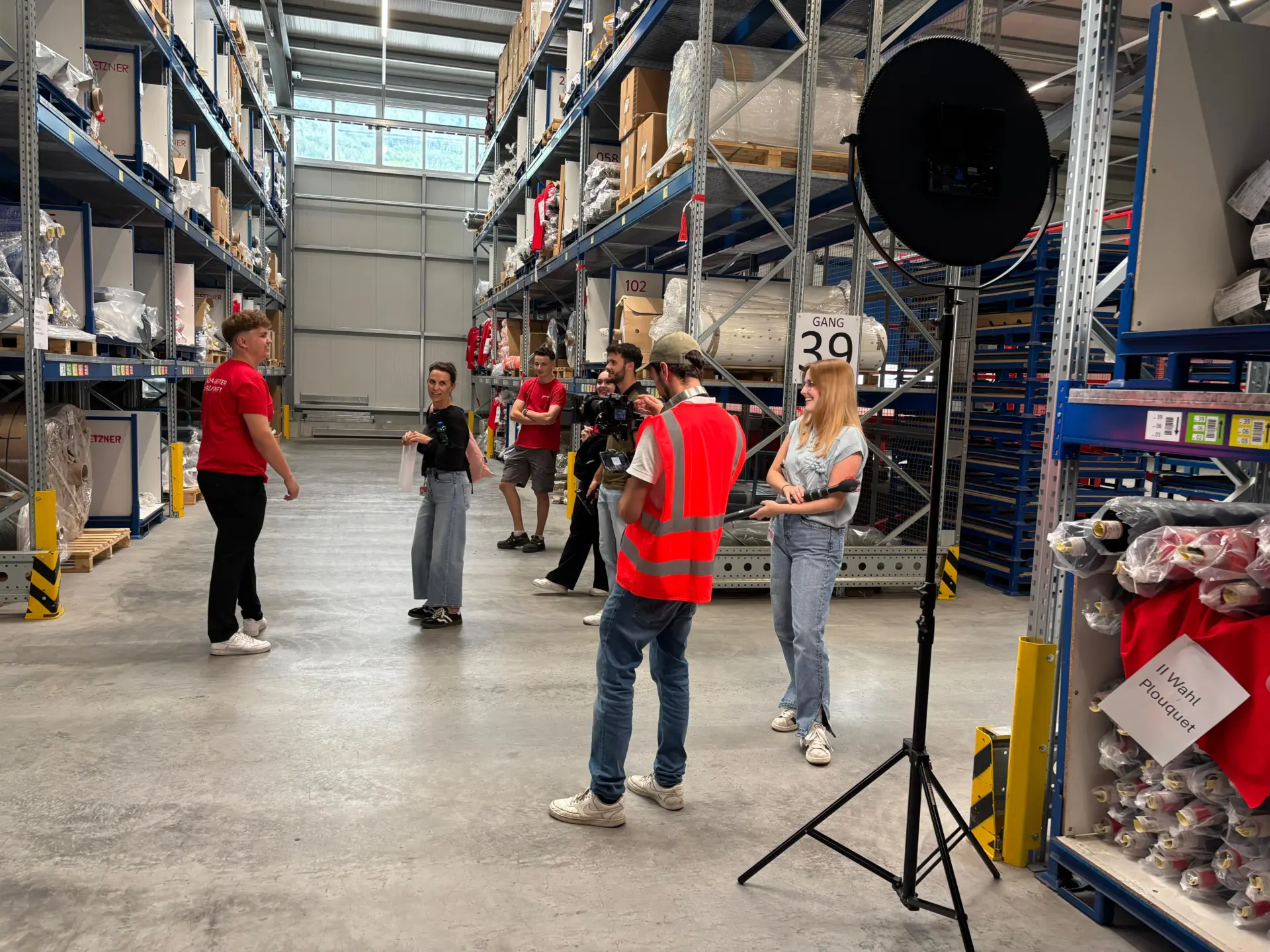 Fotografen und Team in Lagerhalle bei Dreharbeiten