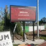 Willkommensschild der MULTIMEDIAFABRIK im Freien aufgestellt.
