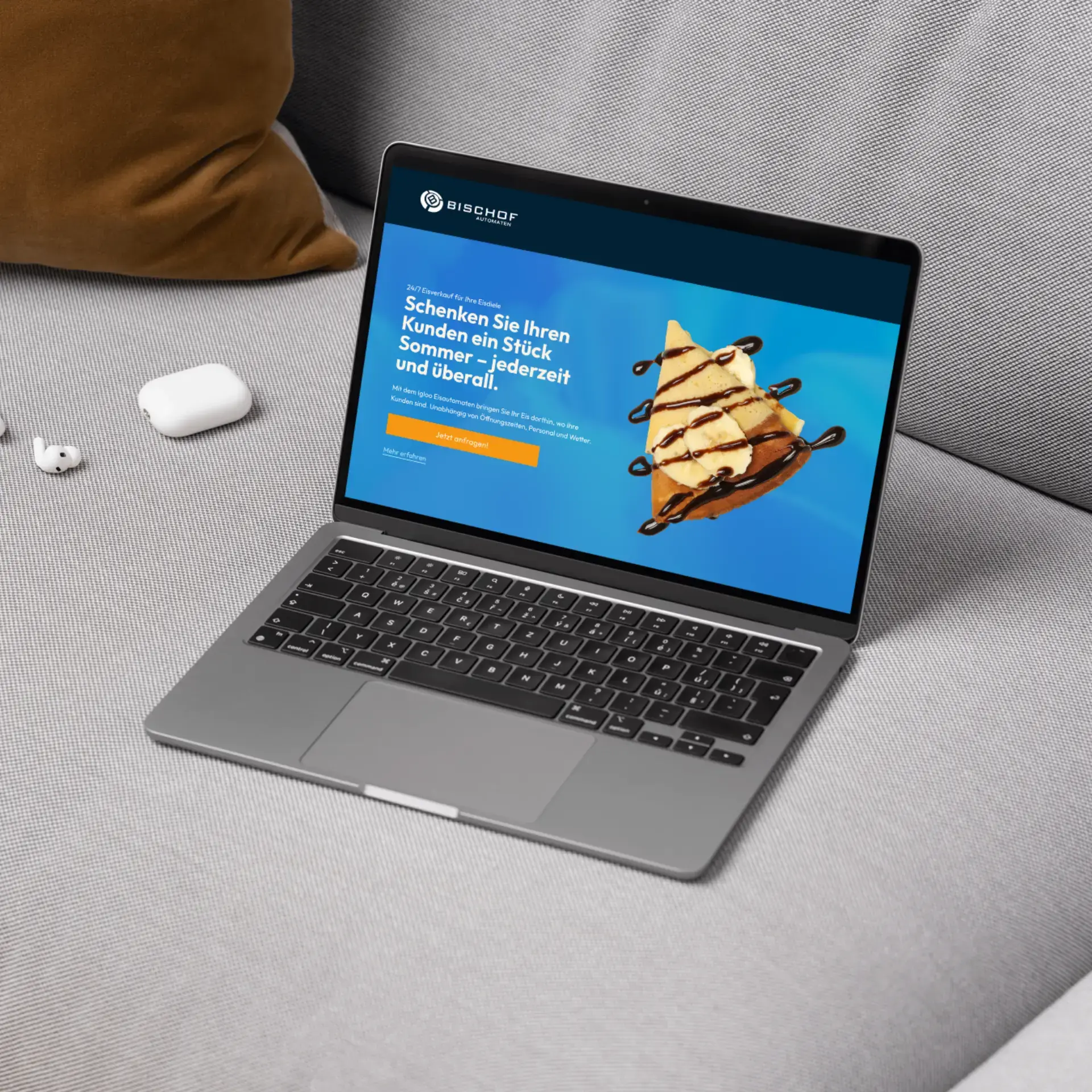 Laptop auf grauem Sofa mit Werbung