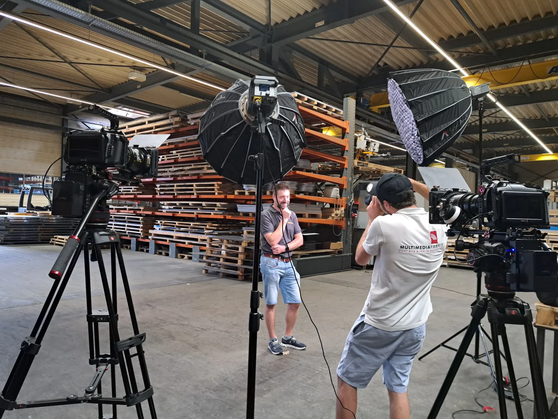 Filmteam dreht in Lagerhalle mit Beleuchtung.