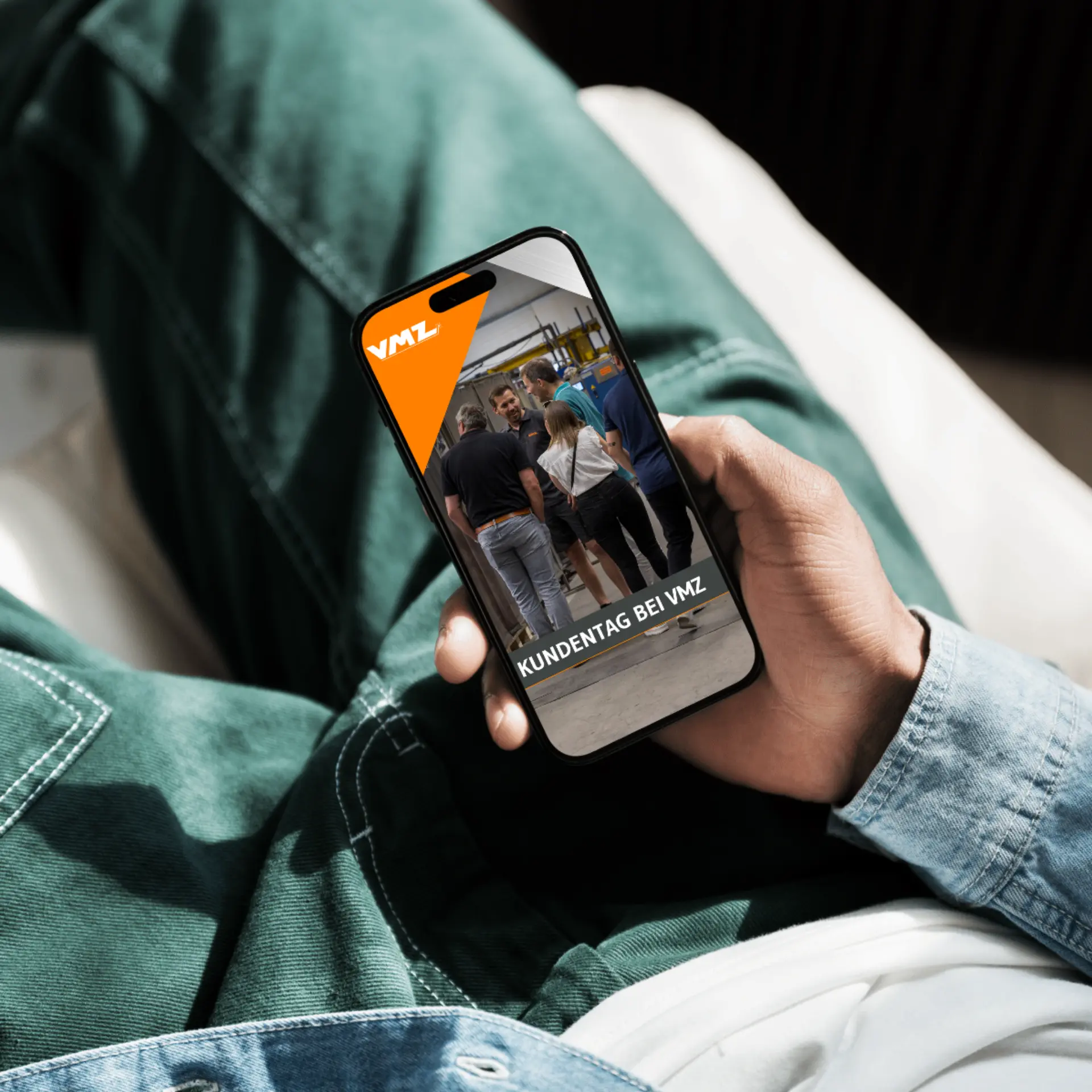Person hält Smartphone mit Bild vom Kundentag.