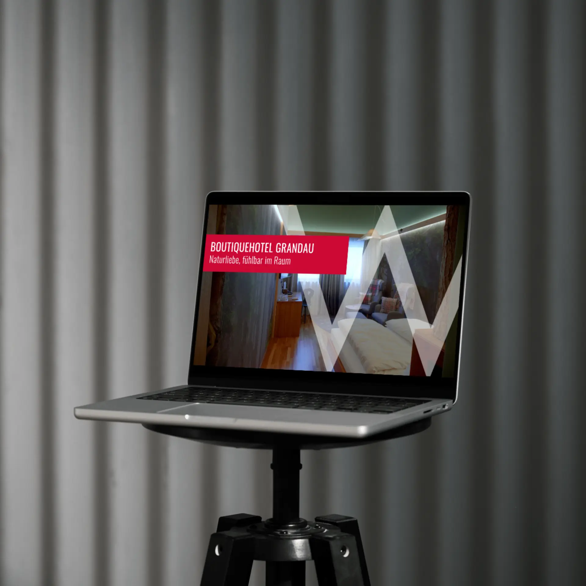 Laptop zeigt Hotelwerbung auf einem Stativ