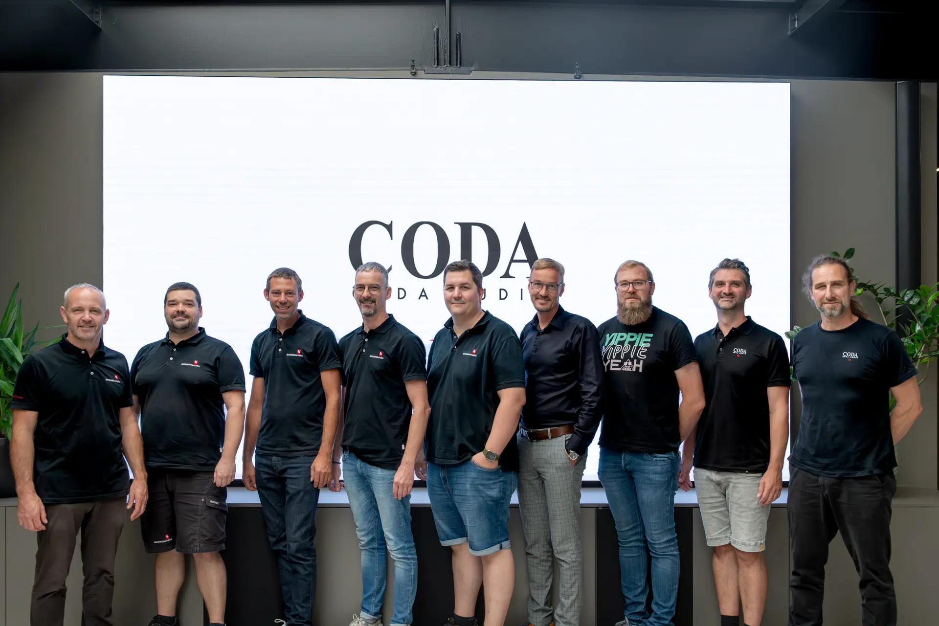 Gruppe von Männern vor CODA-Logo.