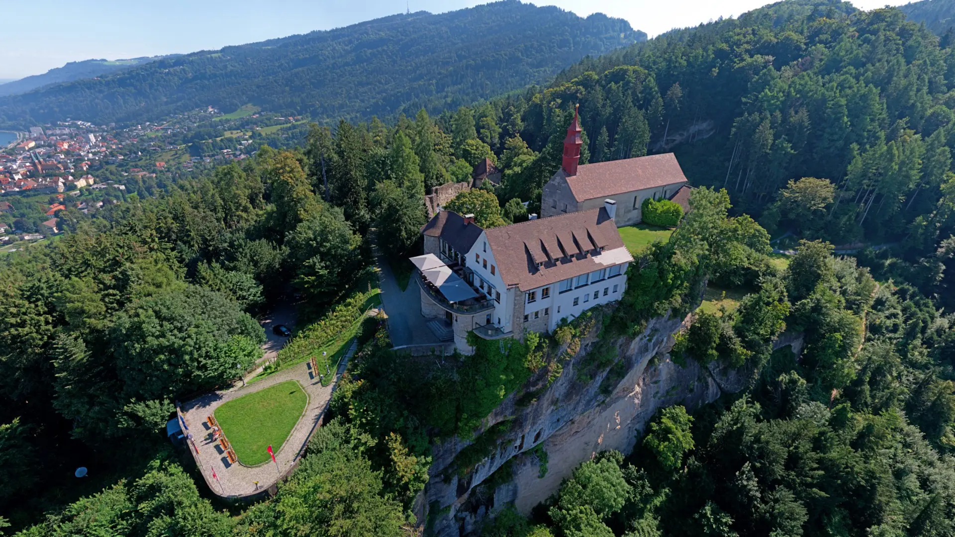 Kloster auf Hügel in waldreicher Landschaft