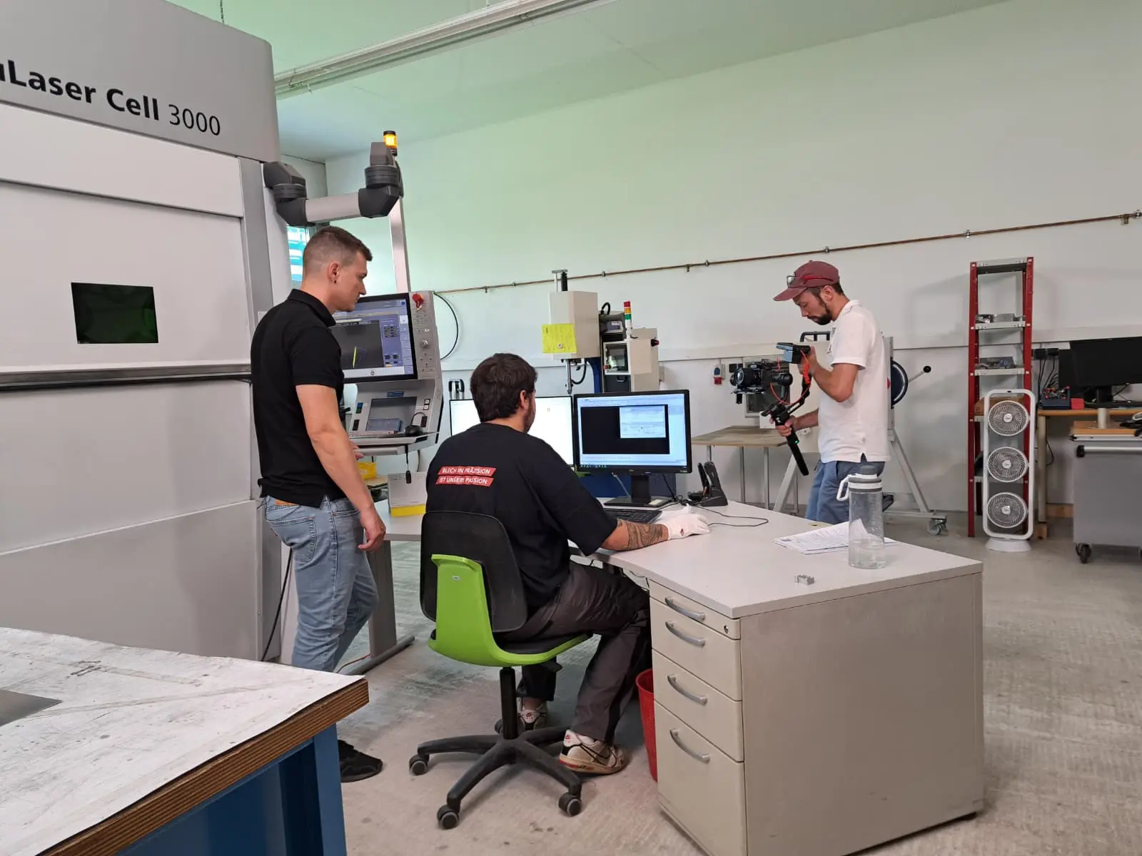 Personen arbeiten in einer Laserzelle.