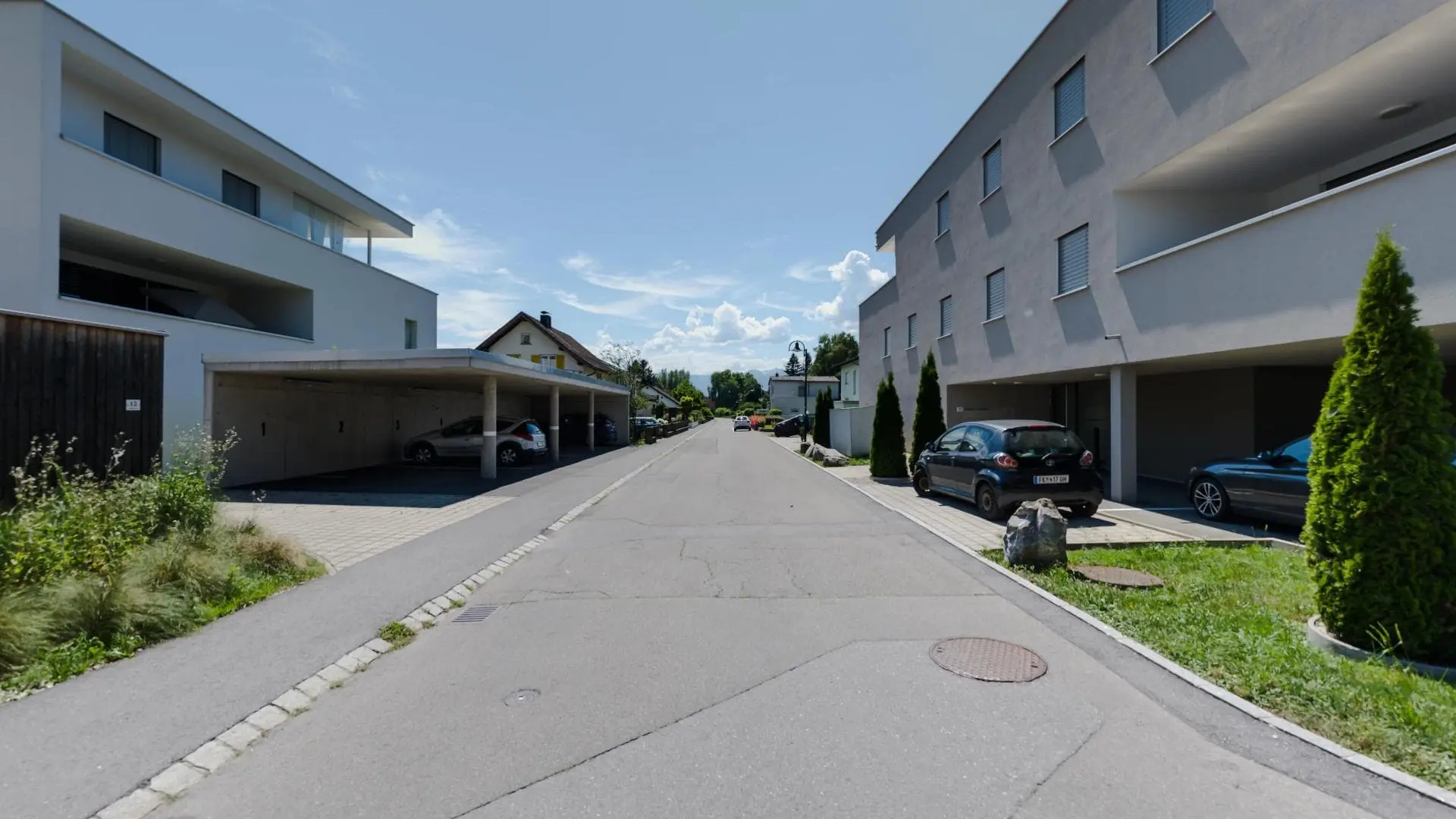 Ruhige Wohnstraße mit geparkten Autos.