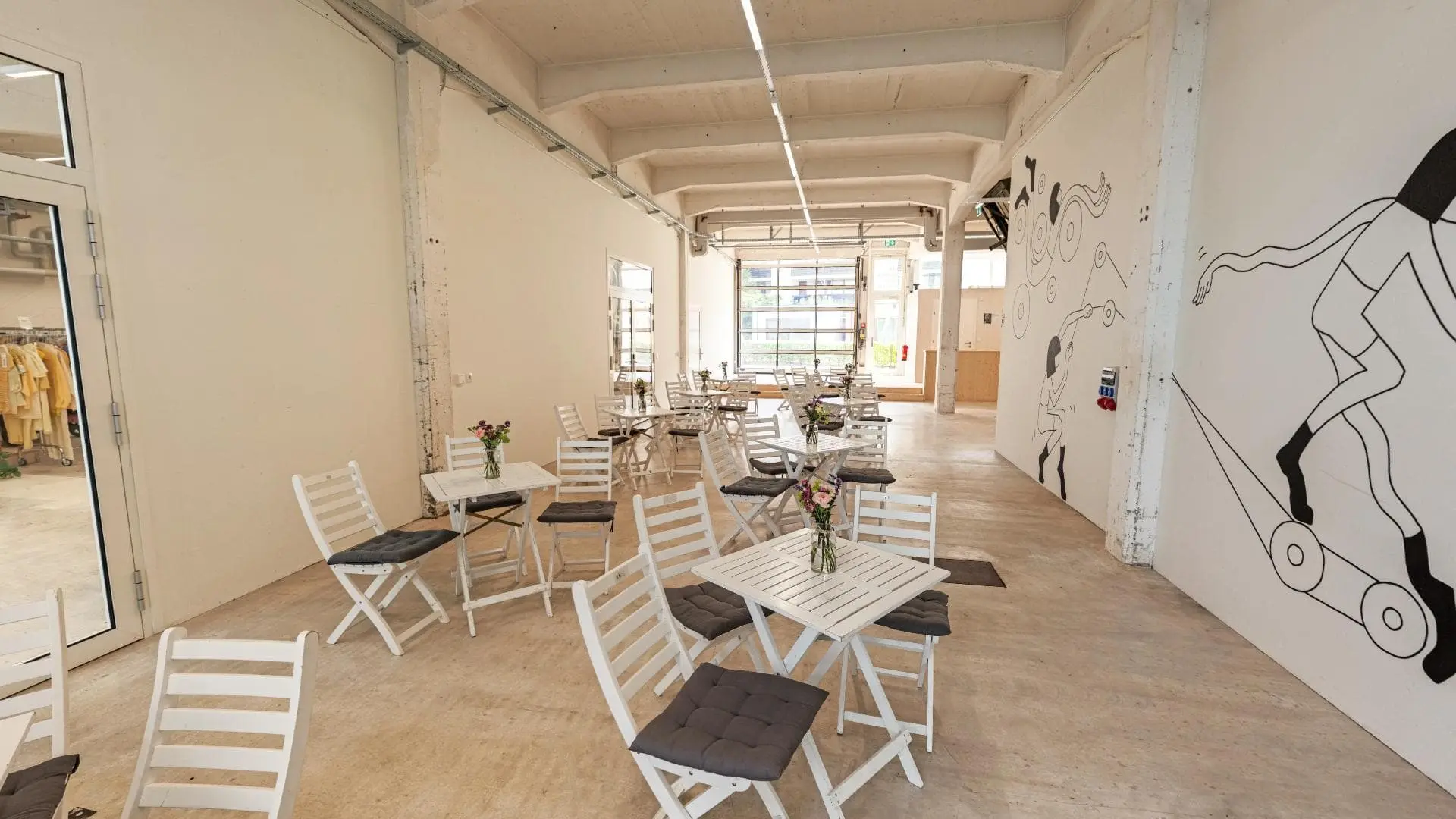 Leerer Raum mit weißen Tischen und Stühlen.